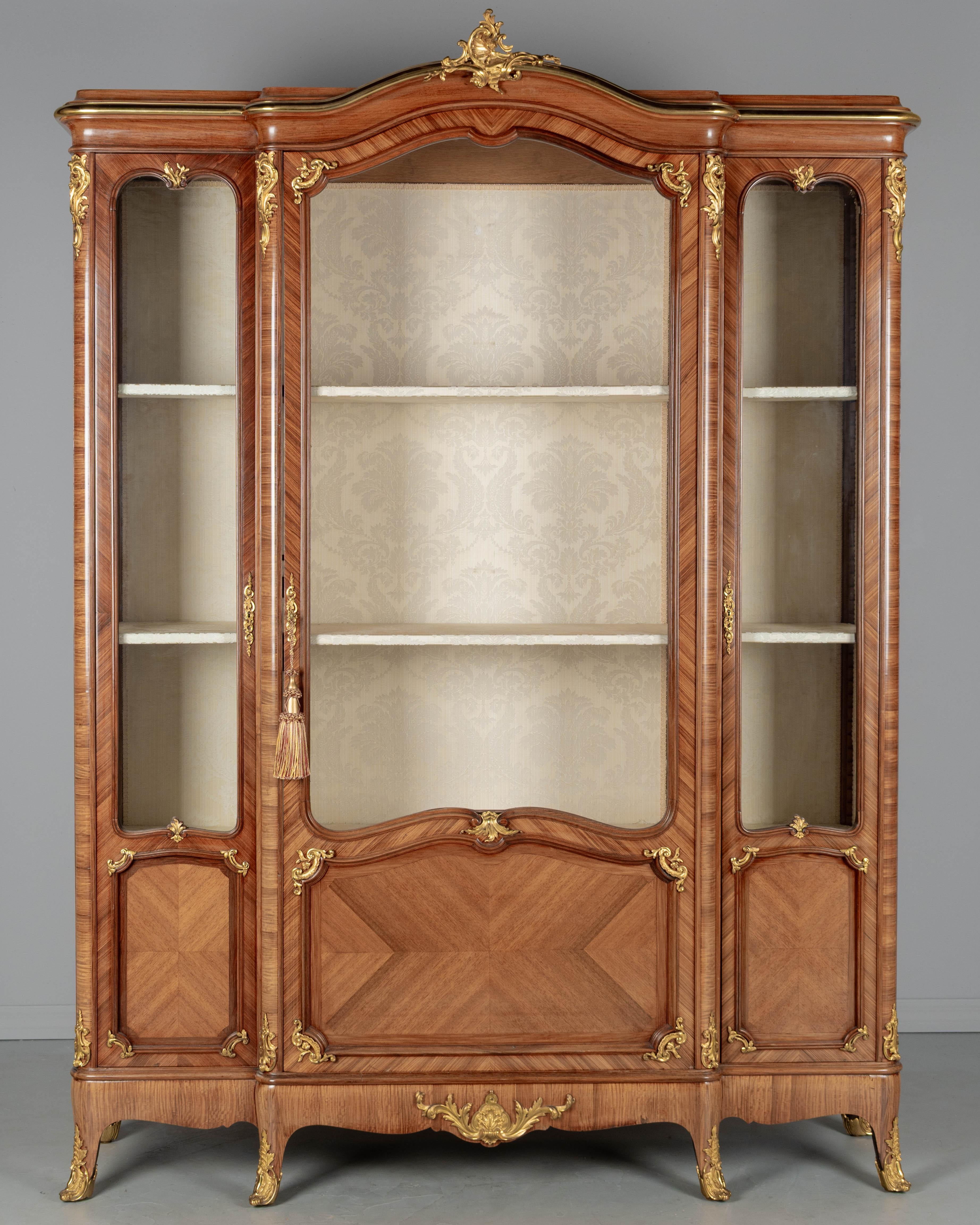 Un'antica e raffinata bibliotheque (libreria) francese in stile Luigi XV, o vetrina realizzata dal maestro ébéniste Schmit & Cie. Realizzato a mano con impiallacciature di kingwood esotico, abbinate e incrociate per un effetto scenografico. Le