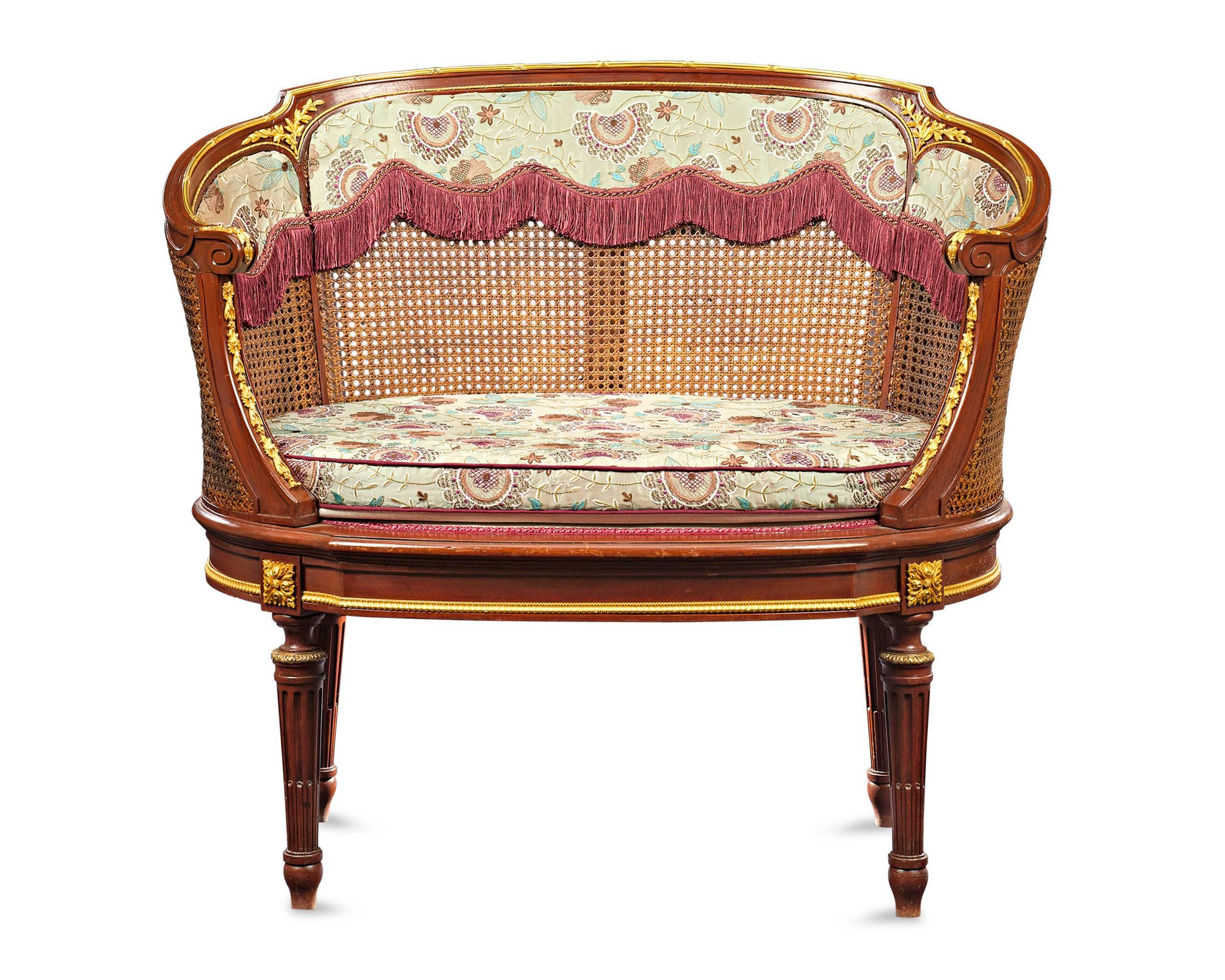 This exquisite pair of 19th century French settees captures the spirit of the Louis XV style. The versatile chairs are exquisitely crafted with gracefully curved, double caned seat backs, while bronze ormolu accents add a hint of luxury to the