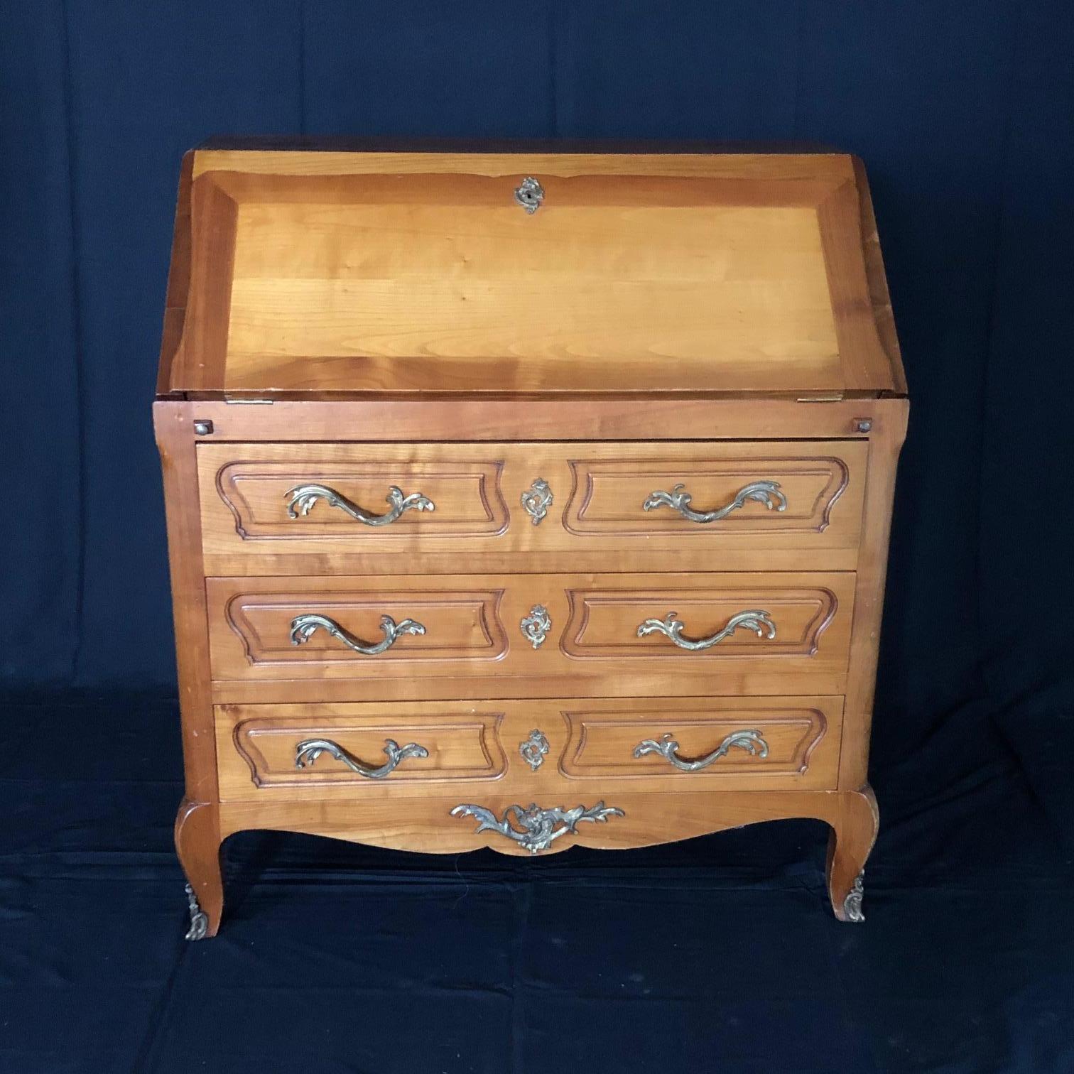Louis XV style carved oak drop front secretary bureau or writing desk, when opened revealing a fitted desk interior with four drawers and a large writing area held by two pull out supports. The original embossed beige leather writing surface is in