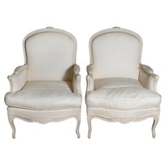 Louis XV Style French Cream Painted Wood Carved Bergères Chairs, a Pair