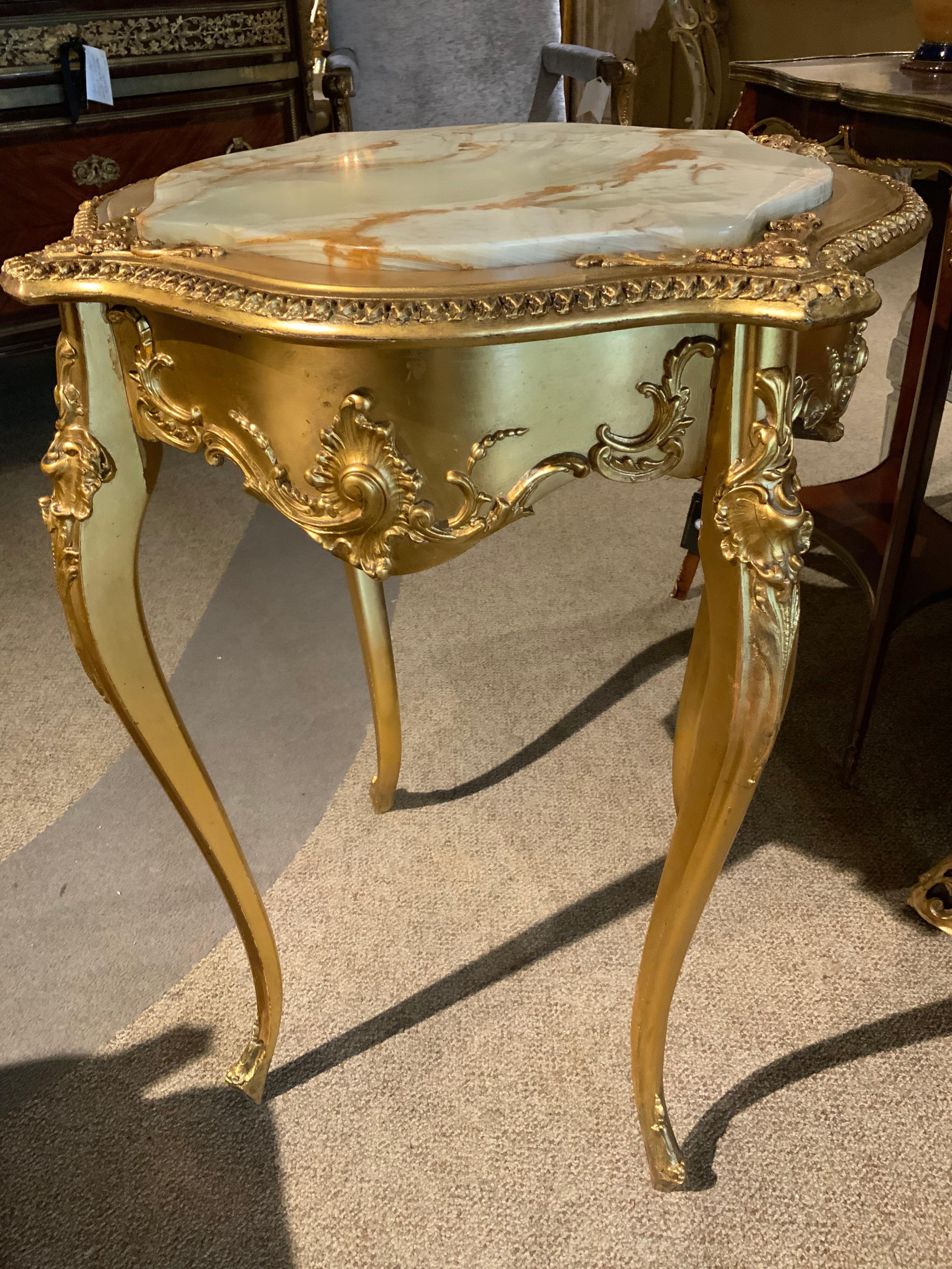 The gilding on this piece is exceptional in quality with a light
Patina and it is in beautiful condition. The shaping on this piece
Is superb with oval sides and the the top is a pale gold alabaster
That is inset into the table.  The legs are