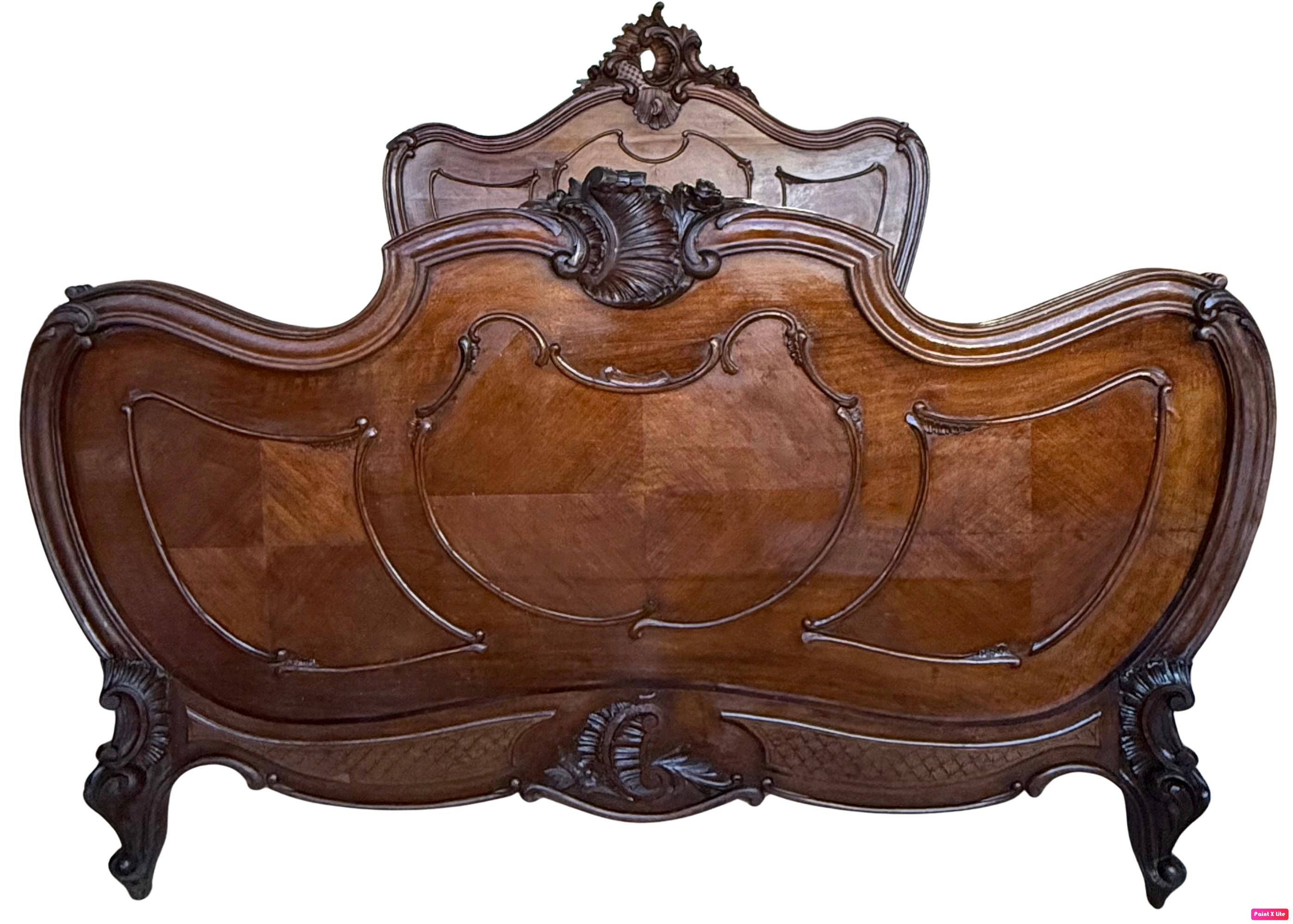  Le lit présente un écusson superbement sculpté sur le pied de lit et un autre plus petit sur la tête de lit. La décoration sculptée est répétée sur les pieds. 
