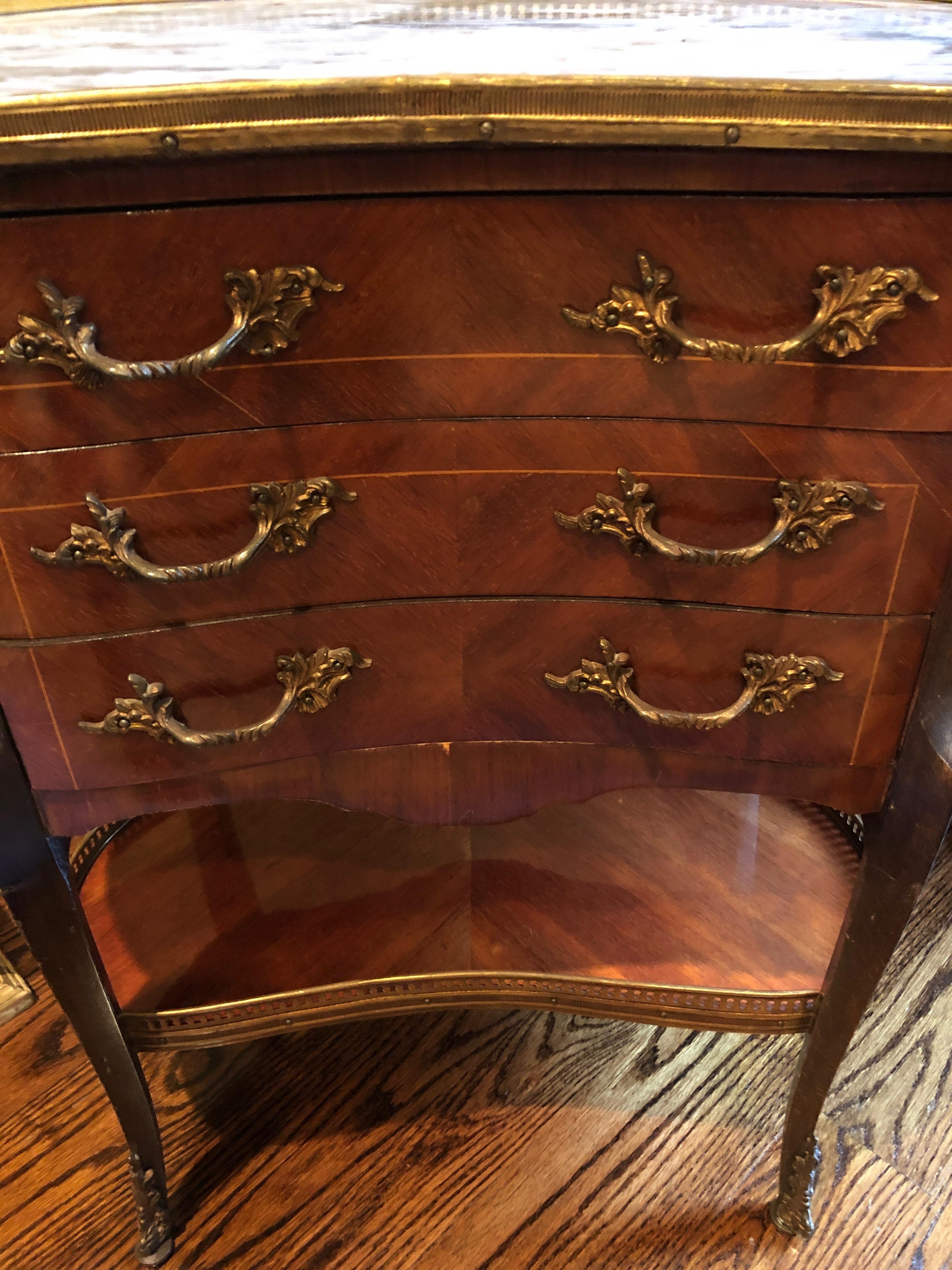Louis XV style figured fruitwood veneered kidney shaped side table with marble top, gilt brass mounts and brass gallery top. There are 3 strung drawers with Rococo cast brass drawer pulls.
 