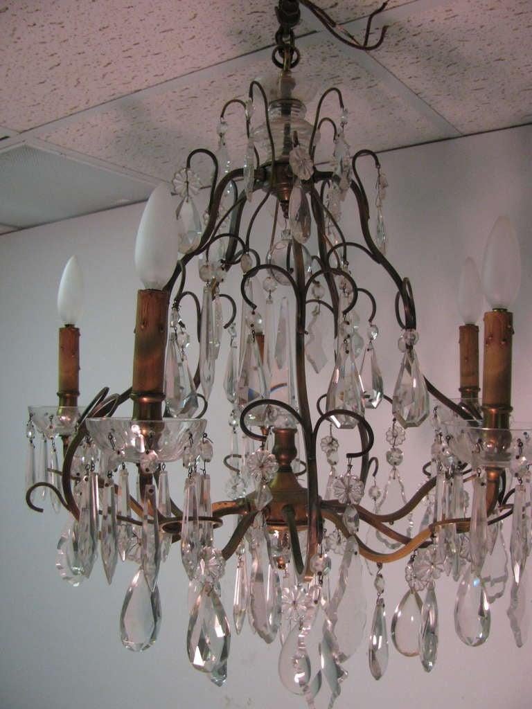 Beautiful and quite elegant chandelier with eight different shapes of beveled and cut glass prisms. Center cut glass bishop. Five lights to illuminate an intimate setting. In excellent vintage condition with minimal wear, nice patina to the brass.