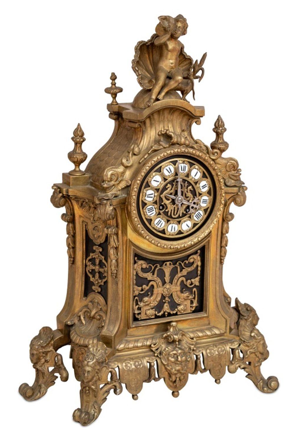 Louis XV Style Gilt Brass Mantel Clock, late 19th century, case surmounted by a cherub seated by a clamshell, surrounded by seashells and dolphins and fishtails, the circular dial with enameled numerals, the movement strike on bell, on an
