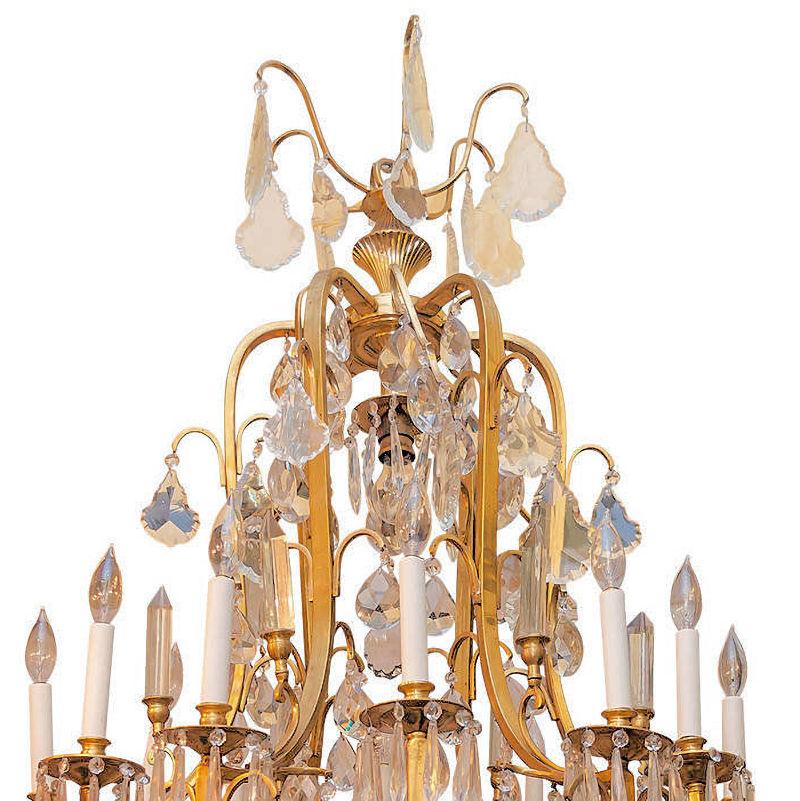 Très grand lustre impressionnant de style Louis XV en bronze doré et cristal à douze lumières mesurant 32 par 60 pouces, avec plus de 250 pendentifs en cristal dans une variété de formes facettées, plus huit douilles standard à la base et une