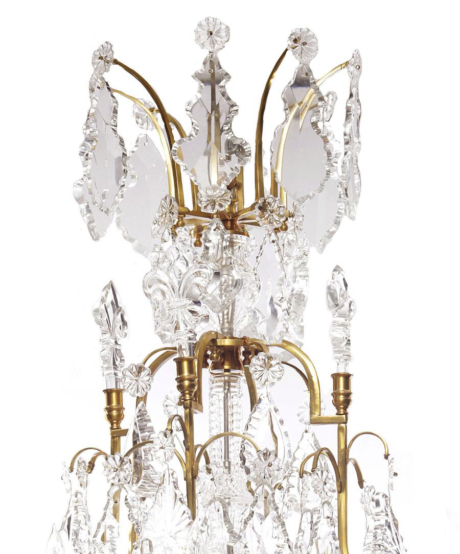 Lustres à seize lumières de style Louis XV en bronze doré et cristal de plomb, les cadres en bronze massif avec des tours, des fleurs de lys et un support central, attribués à Baccarat. Circa : 20ème siècle. 

Hauteur : 67 pouces (170,2 cm)
Largeur