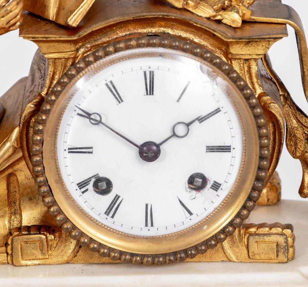 Pendule de cheminée figurative en bronze doré et marbre blanc de style Louis XV, milieu du 19e siècle, le cadran en émail blanc, avec mouvement à sonnerie, surmonté d'une dame allongée tenant un livre et une couronne, sur une base rectangulaire