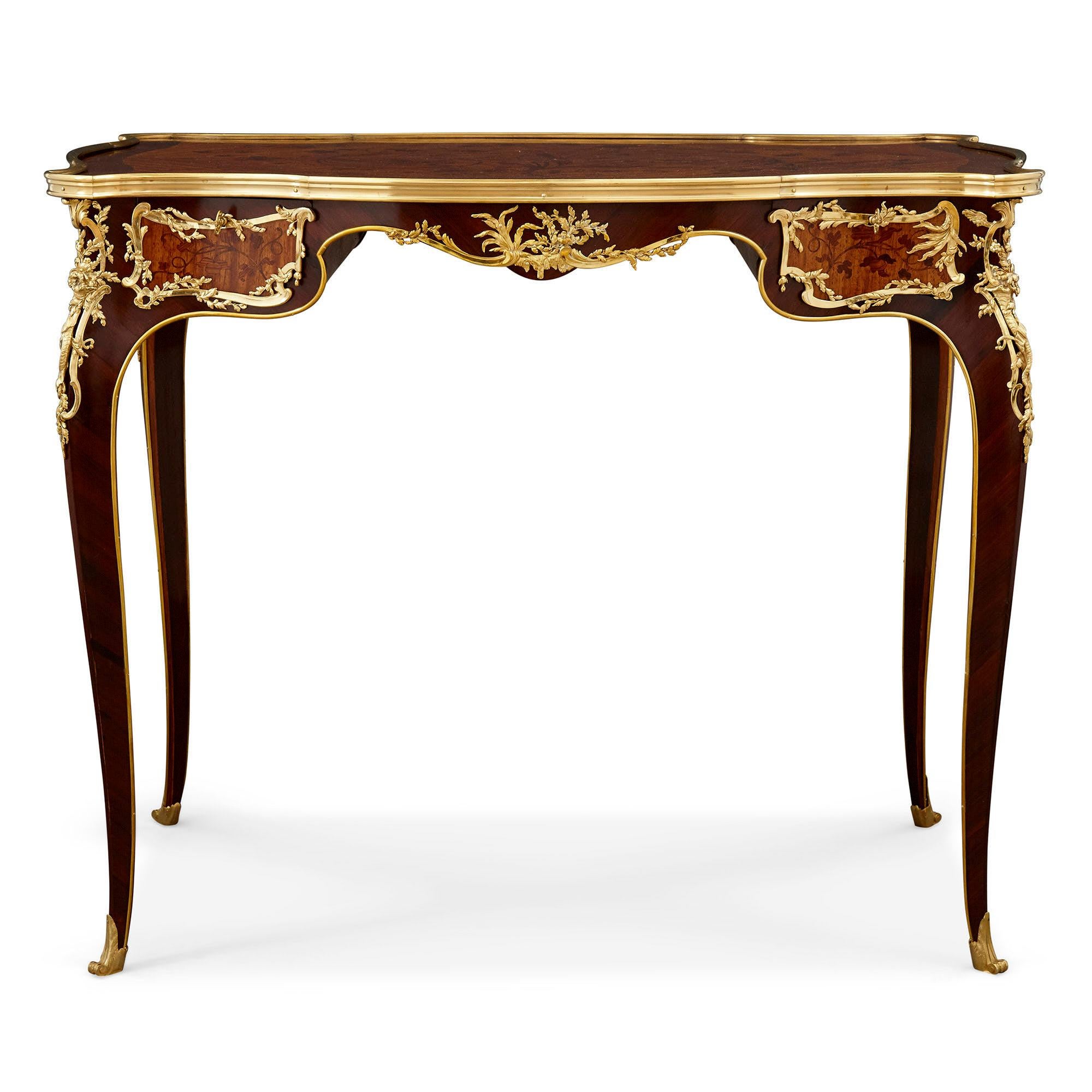 Schreibtisch im Stil Louis XV aus vergoldeter Bronze und Intarsien, Zwiener zugeschrieben
Französisch, Ende 19. Jahrhundert
Maße: Höhe 74cm, Breite 89cm, Tiefe 63cm

Dieser prächtige kleine Schreibtisch wird dem bedeutenden Möbelhersteller