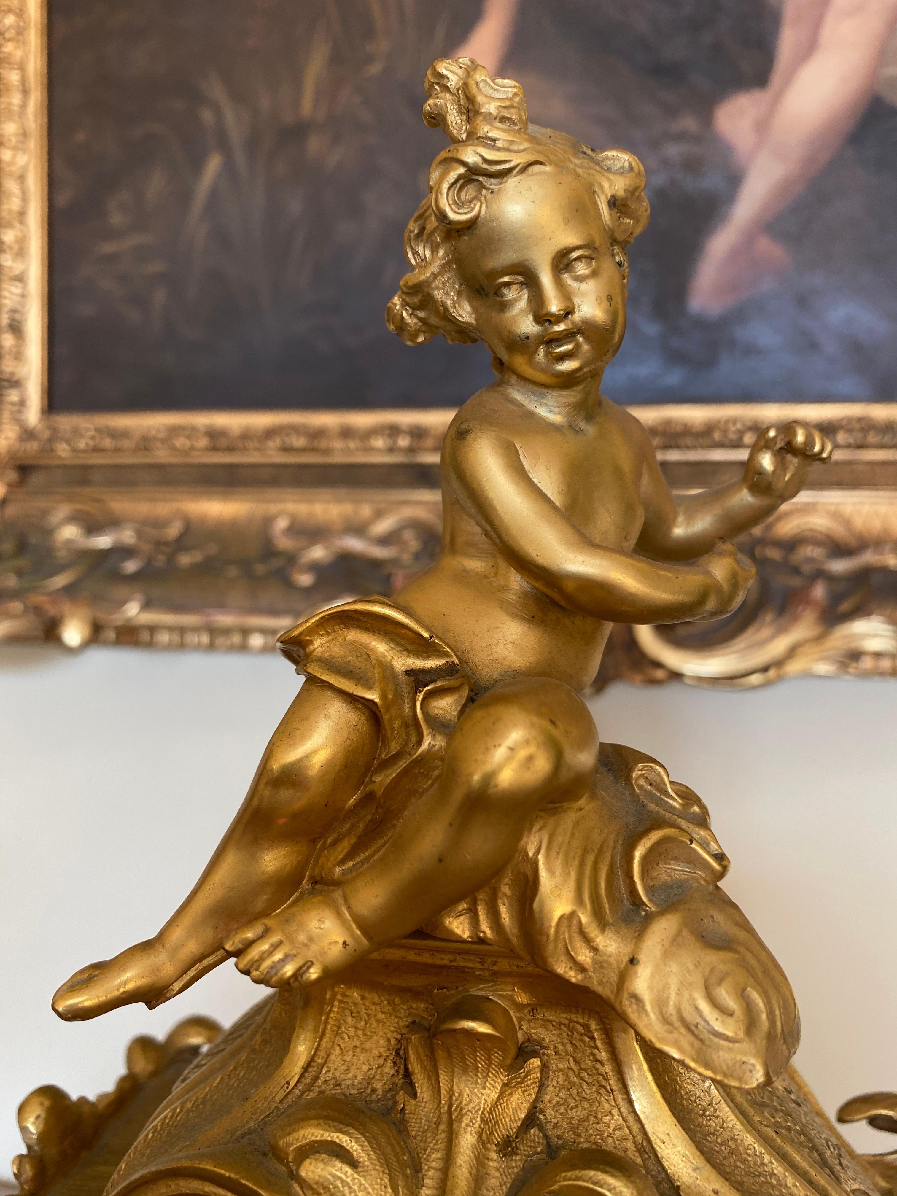 Pretty gilt bronze clock in the Louis XV rococo style surmounted by a putti. Front and sides in honeycomb style. Very beautiful original gilding. Complete pendulum, mechanism to be revised.