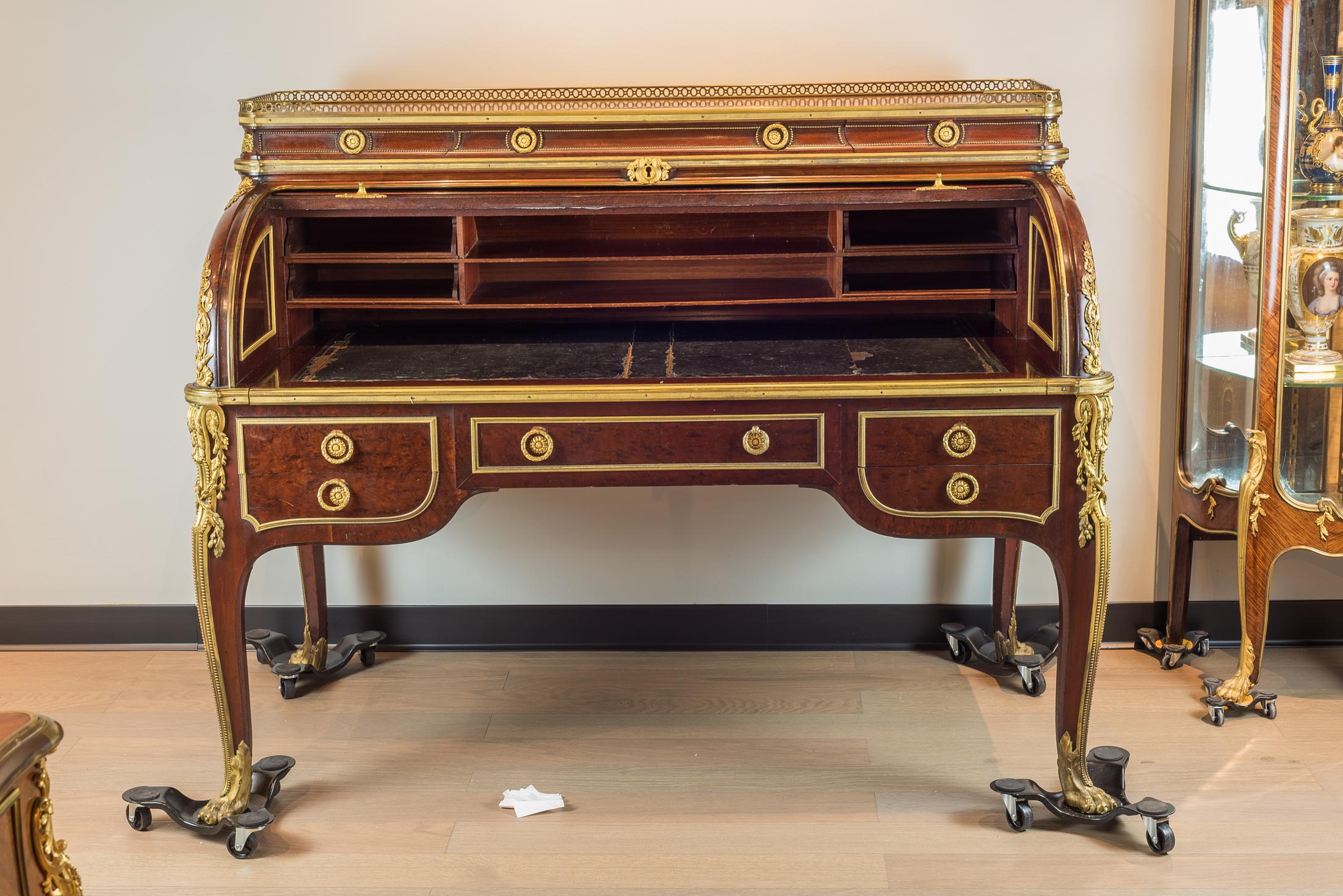 A stunning cylinder desk with roller shutter in the style of Louis XV, plum pudding mahogany, modeled by Jean-Henri Riesener, signed François Linke. The upper structure fitted with three small drawers, the cylinder opening to six filing compartments