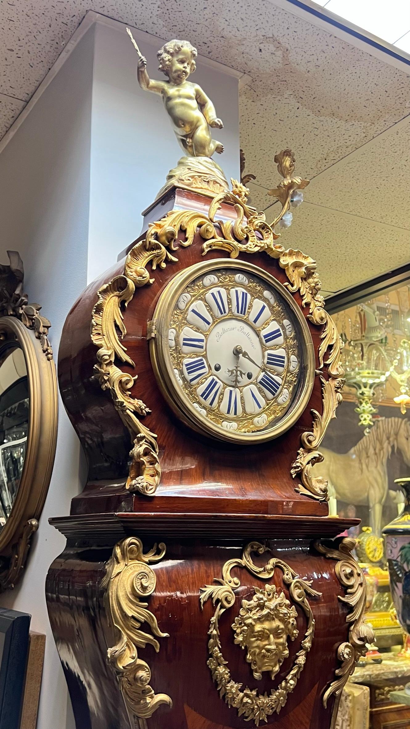 Magnificent late 19th century tall case clock in the French Louis XV style with gilt bronze mounts over case with kingwood veneer after the original model by Charles Cressent (French, 1685-1768), with white porcelain face signed twice Baltazar and 