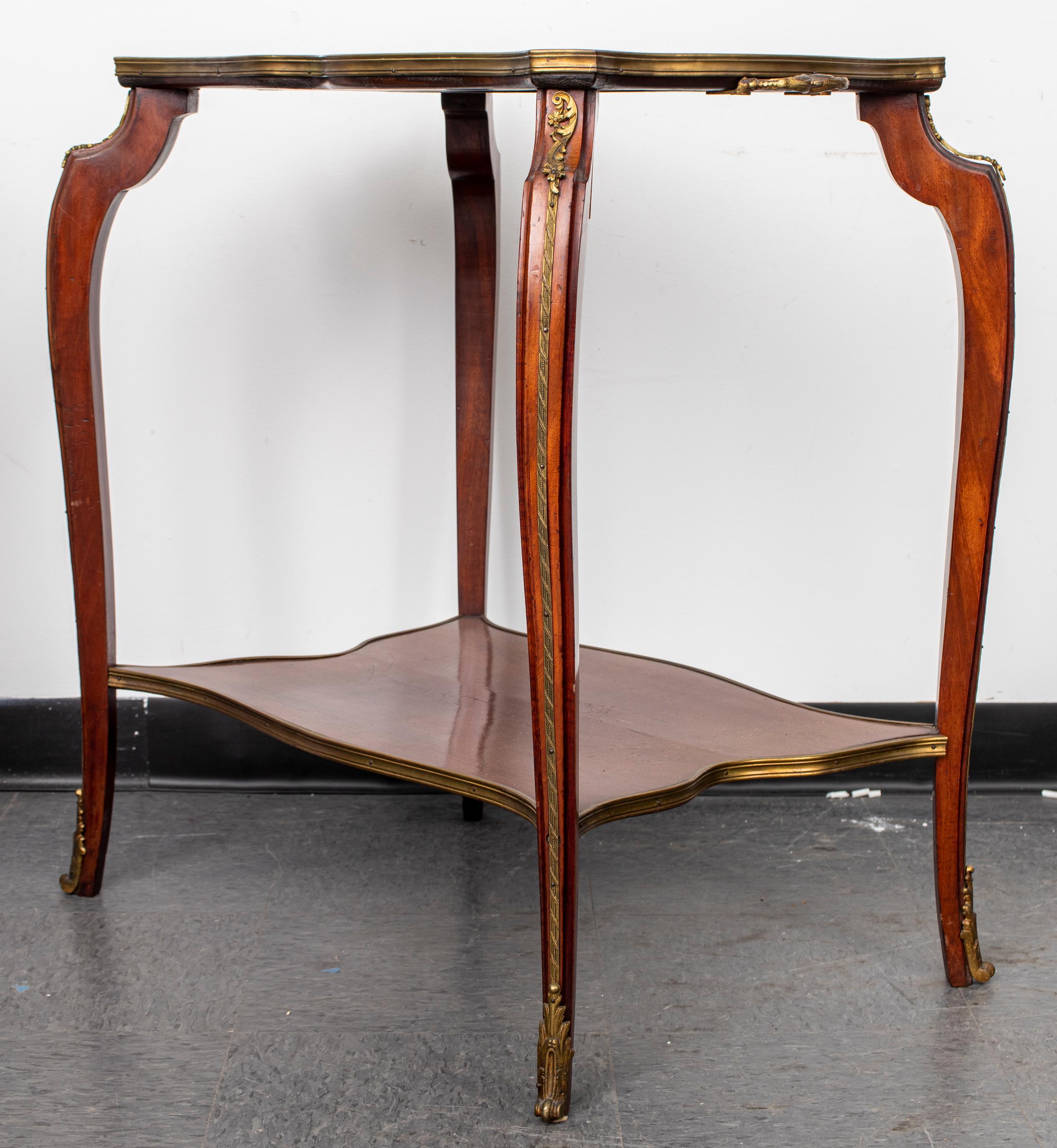 Louis XV style gilt bronze mounted two-tier tea table with pink marble top. 31.25” H x 29” W x 20.5” D.