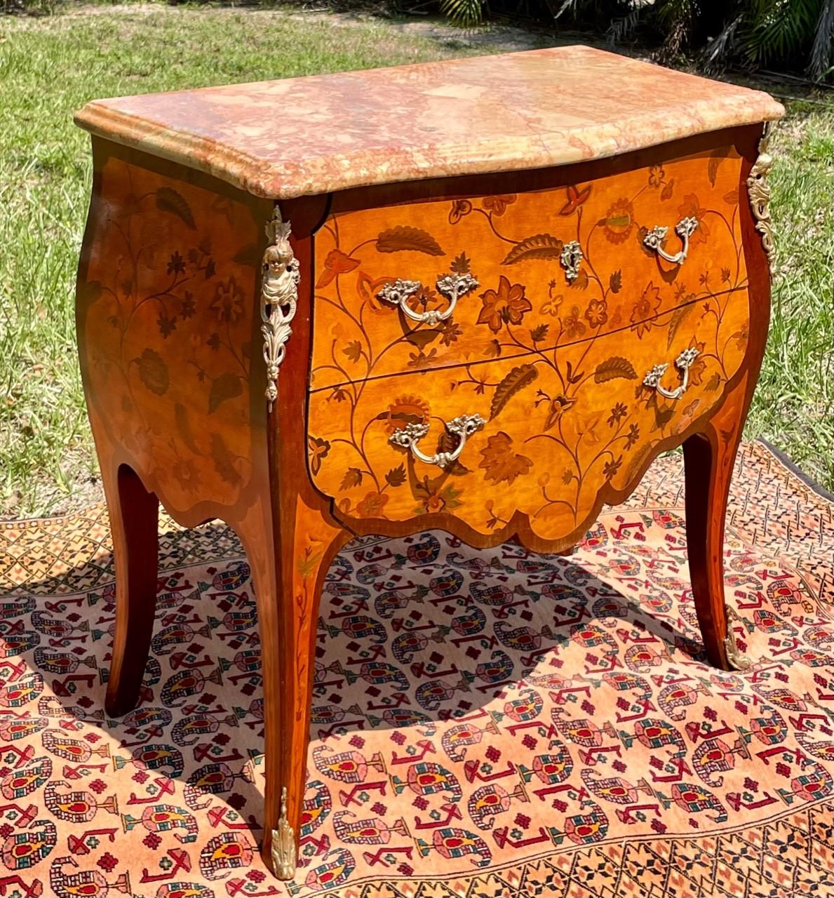 Louis XV style gilt bronze mounted tulipwood marquetry bombe commode. Late 19th century.

Elegant French two drawer marquetry commode. The rectangular pastel marble top sits above two drawers. The commode is veneered with floral marquetry. The