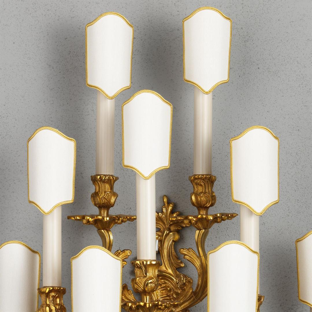 Die vergoldete Bronzewandleuchte im Stil Ludwigs XV. von Gherardo Degli Albizzi ist in traditioneller Weise gegossen und weist die ganze üppige Bewegung des Rokoko auf. Sie hat vierzehn Arme, die von der Platte ausgehen und mit Akanthusblättern und