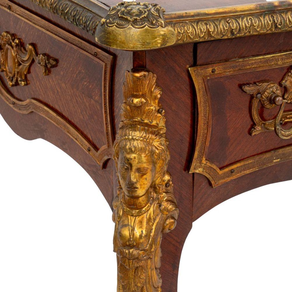 Bureau Plat de madera de Kingwood montado en metal dorado estilo Luis XV, siglo XX, tapa rectangular de cuero sobre un cajón con friso, patas cabriolé con cabeza de mascarón y patas de garra peluda. 30