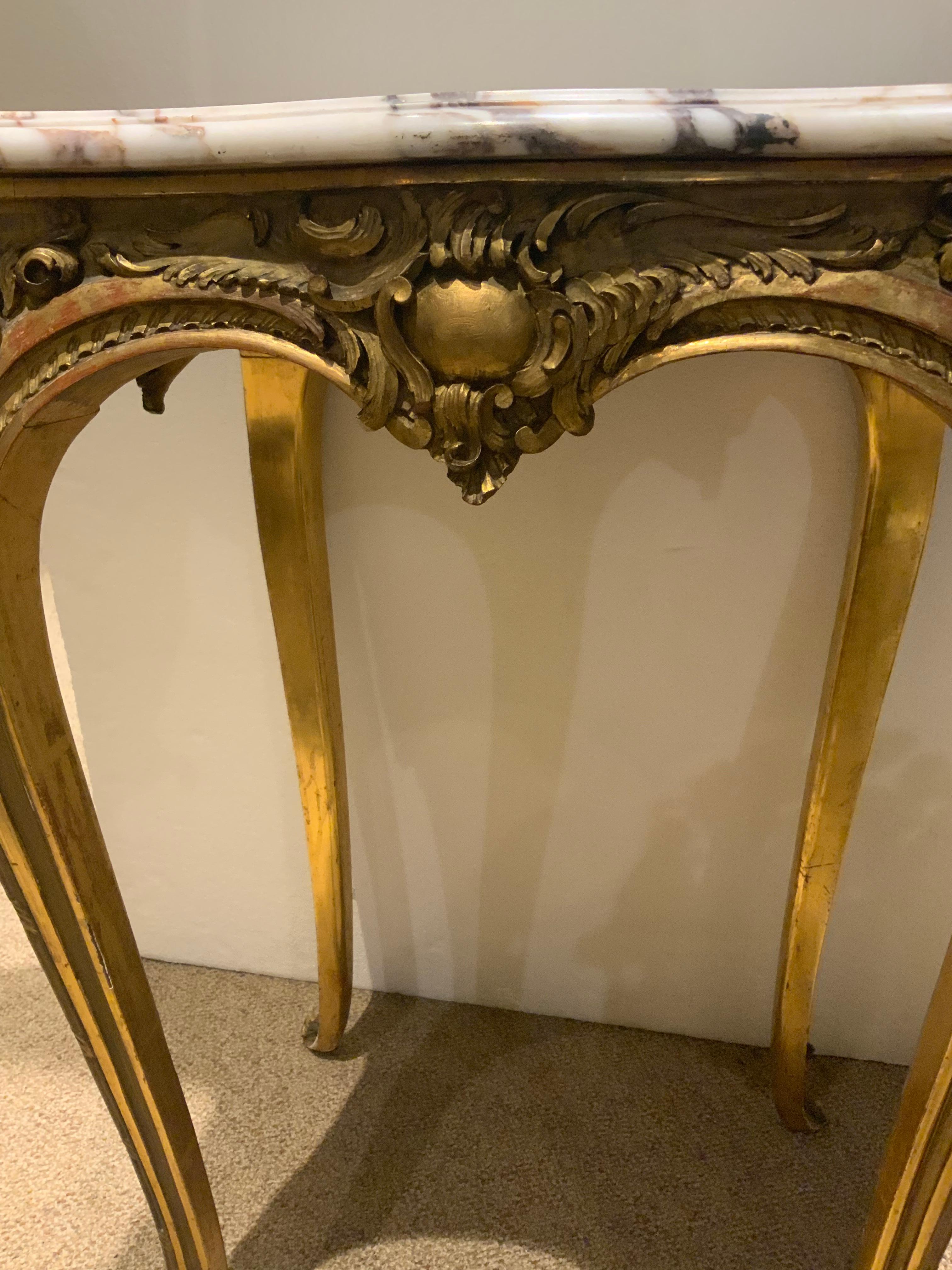 This table is giltwood that has hand carving in the LouisXV-Style.
The curved leg is in the cabriole curved manner. The marble top.
Is original in white and cream colored hues.

 
