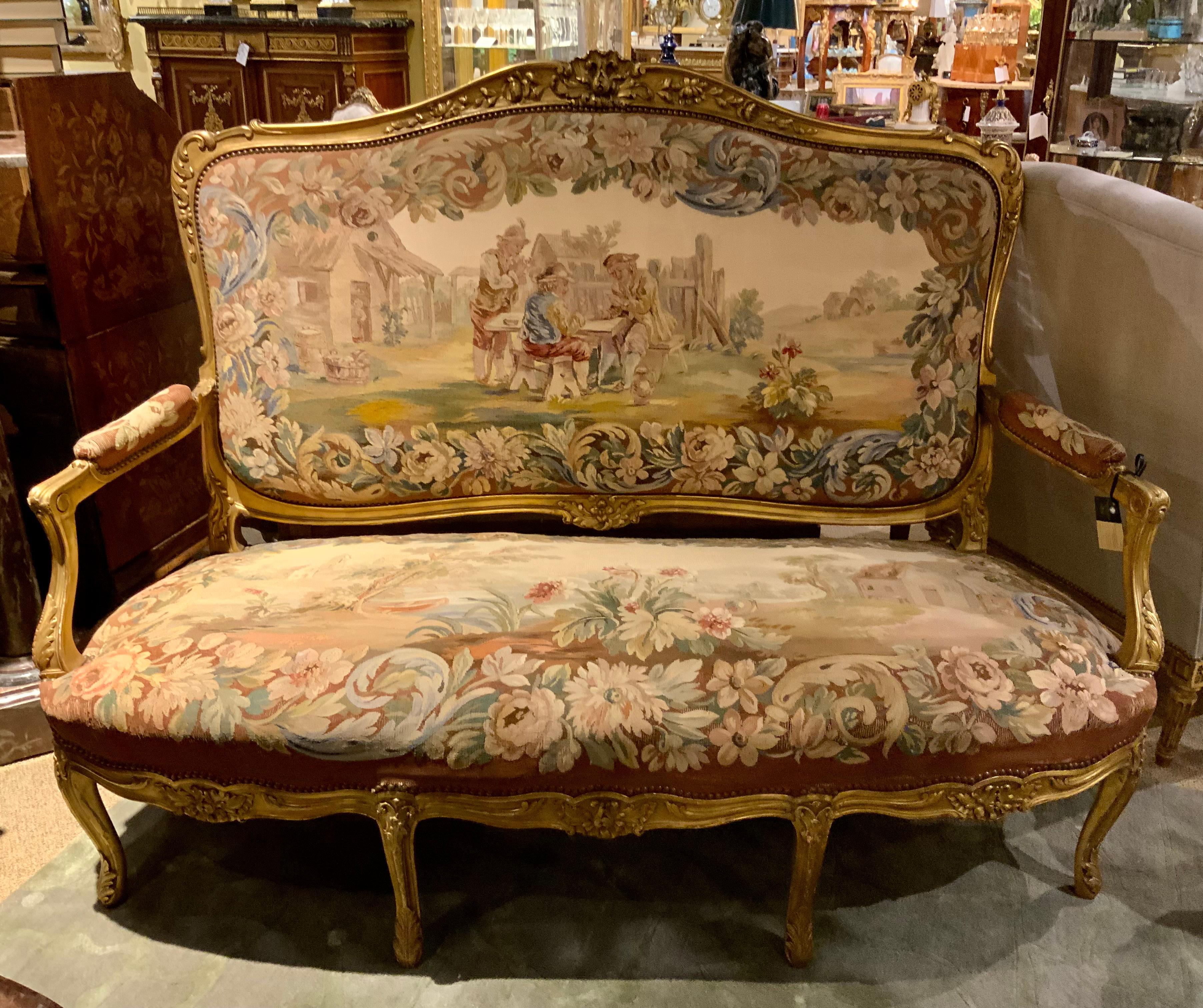 This salon suite is nineteenth century, comprising of a settee
And four arm chairs, each with an arched crest rail centering
A stylized shell  and foliage flanked by blossoming stems above a serpentine rectangular back issuing padded scrolled arms