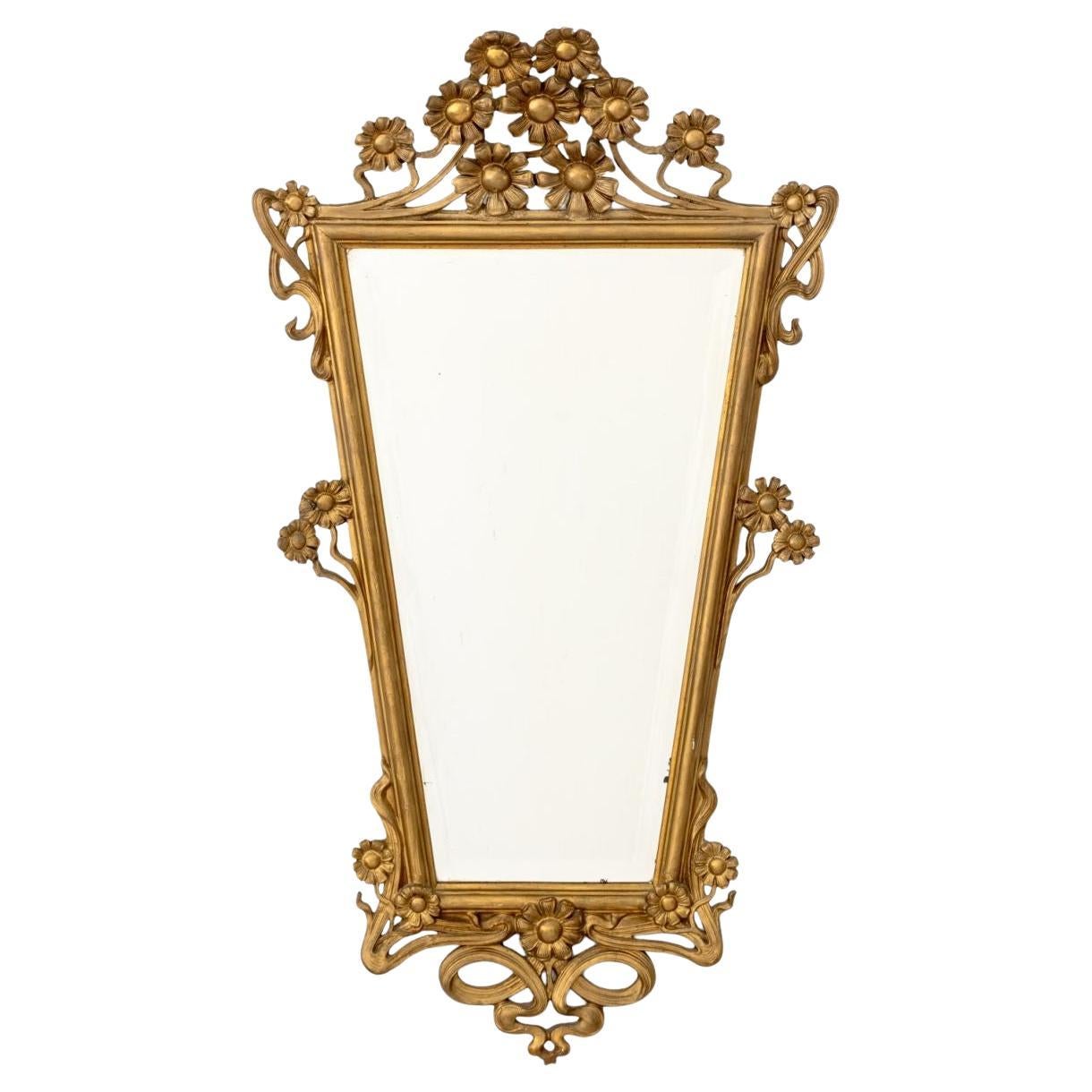 Miroir biseauté encadré en bois doré de style Louis XV