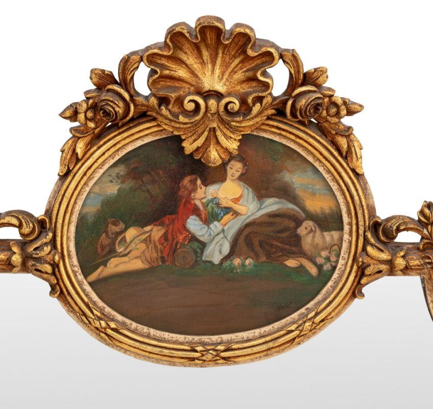 Specchio da camino in legno dorato in stile Luigi XV, fine XIX secolo, tre sezioni, pannello dipinto raffigurante una coppia reclinata, stemma a conchiglia e motivi floreali. 60,5