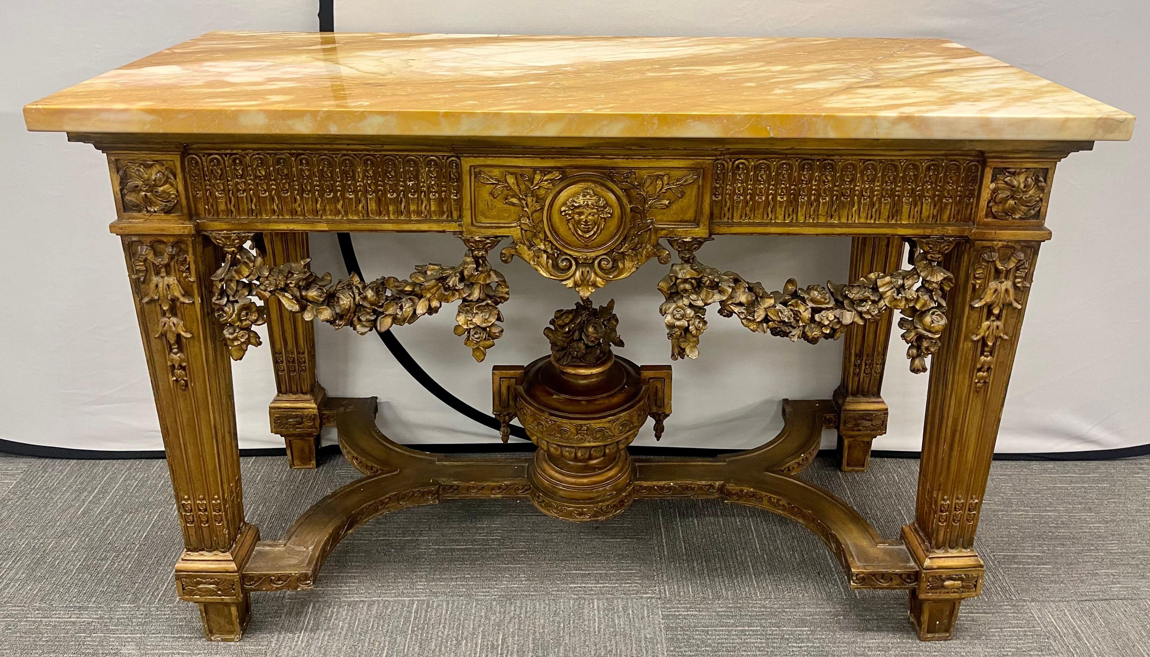 Console en bois doré de style Louis XV du début du siècle, avec plateau en marbre et châssis en forme d'urne. Cette table console finement sculptée représente l'ère de la vie grandiose à son apogée. Dans une finition dorée usée, avec des guirlandes