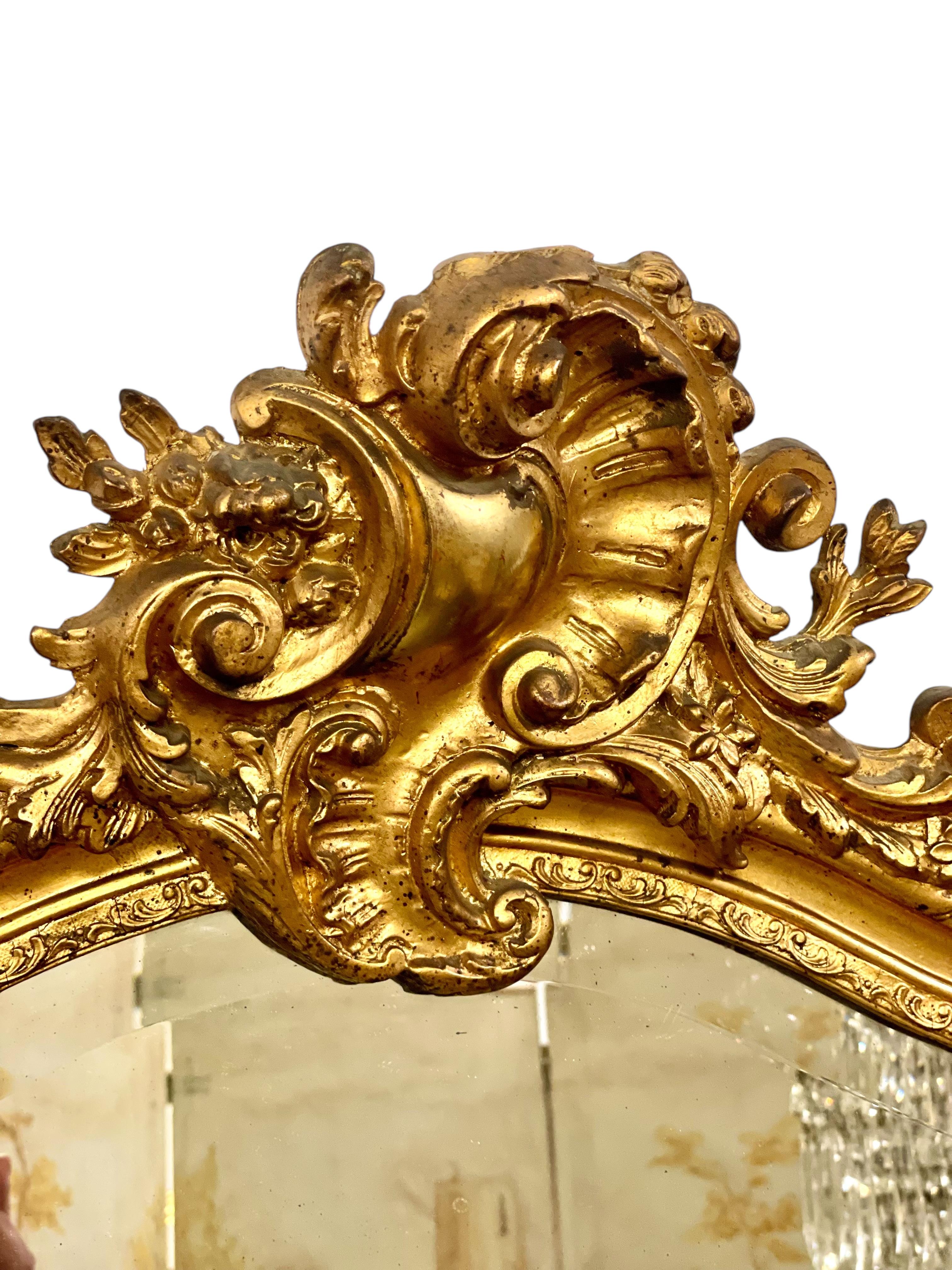 This exceptional antique French mirror is a true statement piece, combining elegance, craftsmanship, and historical charm. Dating from the late 19th century, this impressive mirror is crafted in the Louis XV style and features a richly hand-carved