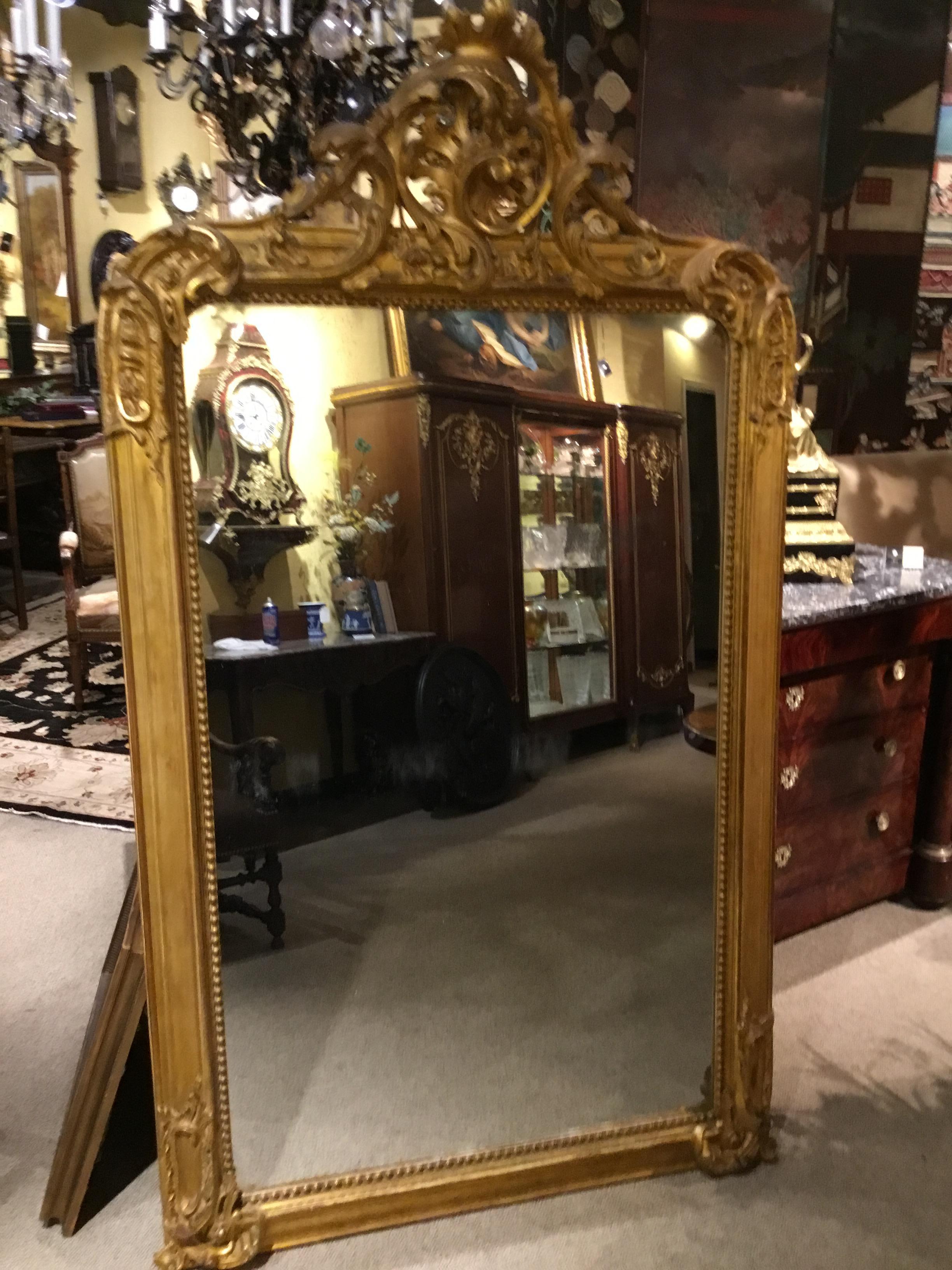 Large and beautiful Louis XV-style mirror with original. Mercury mirror plate.
Flamboyant carved swirls are bat the four corners.