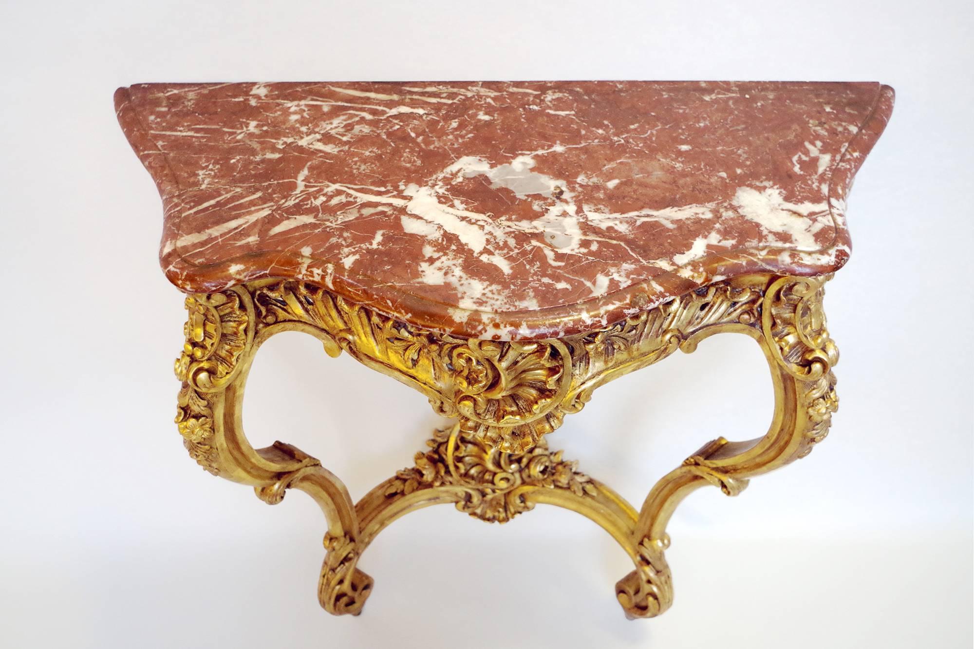 Louis XV style giltwood wall bracket standing on two carved legs ending in winding on shoes and joined by a brace. On the chantourné apron, the top of the legs and the brace, the carved wood is decorated with acanthus leaves, cockscombs and shells,