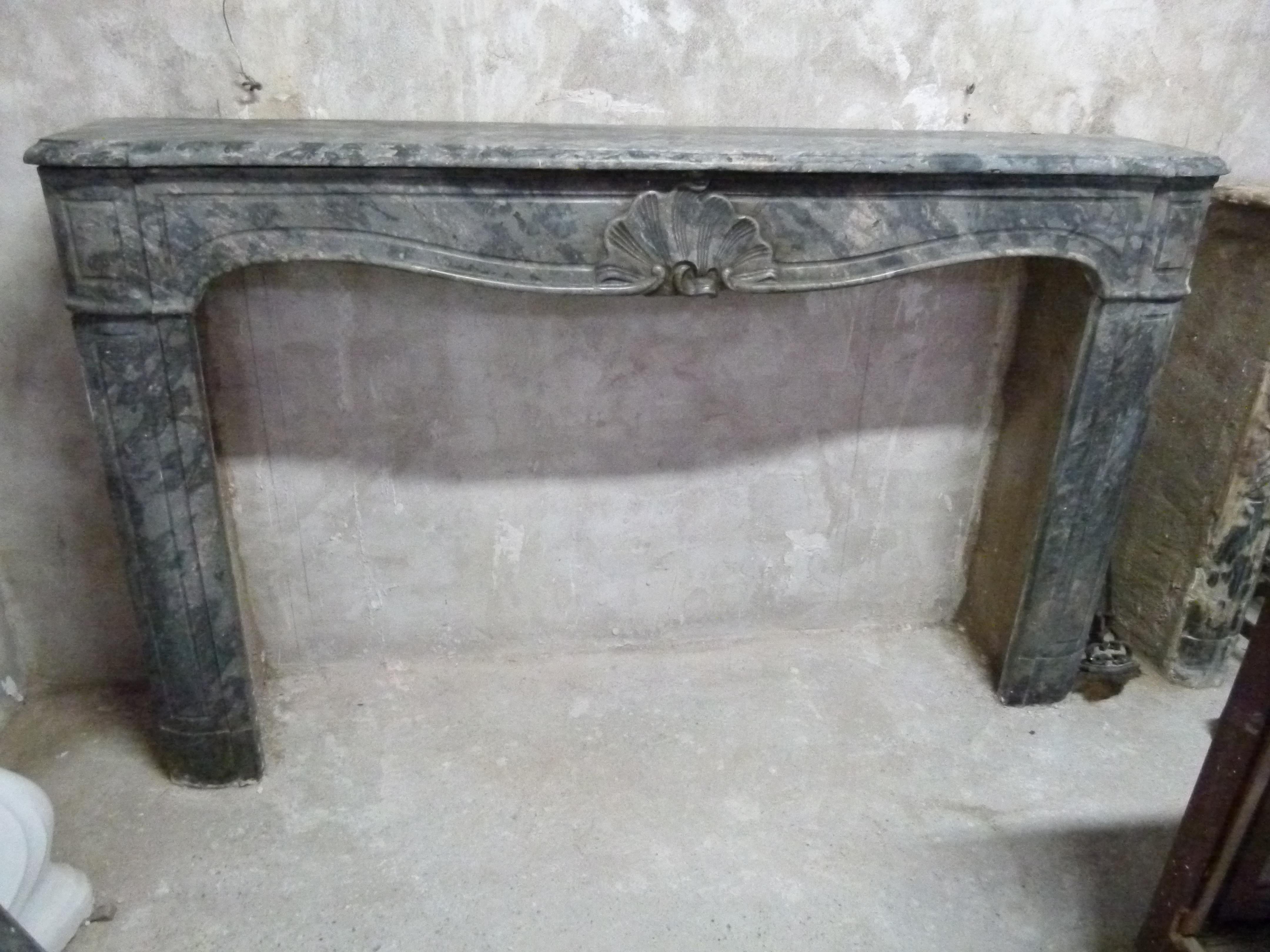 Cheminée de style Louis XV en marbre gris. 
Au XXe siècle, la surface supérieure a été remplacée par une nouvelle pièce de 13 x 195 cm (5,11 x 76,7 in).
  
