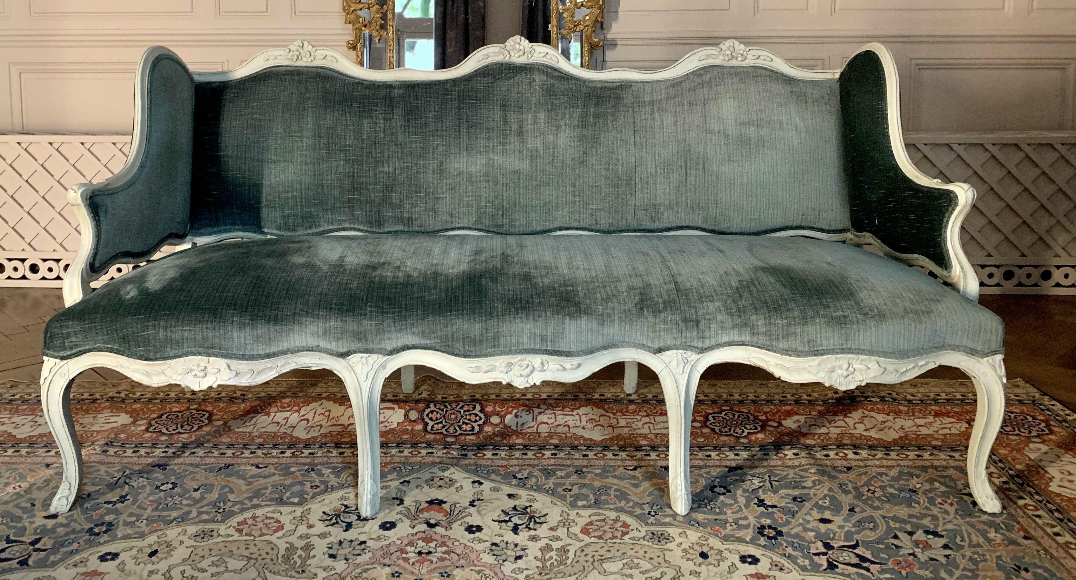 Louis XV style grey - Painted beechwood sofa, 20th century.
In molded beech, carved and gray lacquered, decorated with flowers.
The backrest has a triple evolution, resting on eight arched feet decorated with an acanthus leaf. Blue silk velor