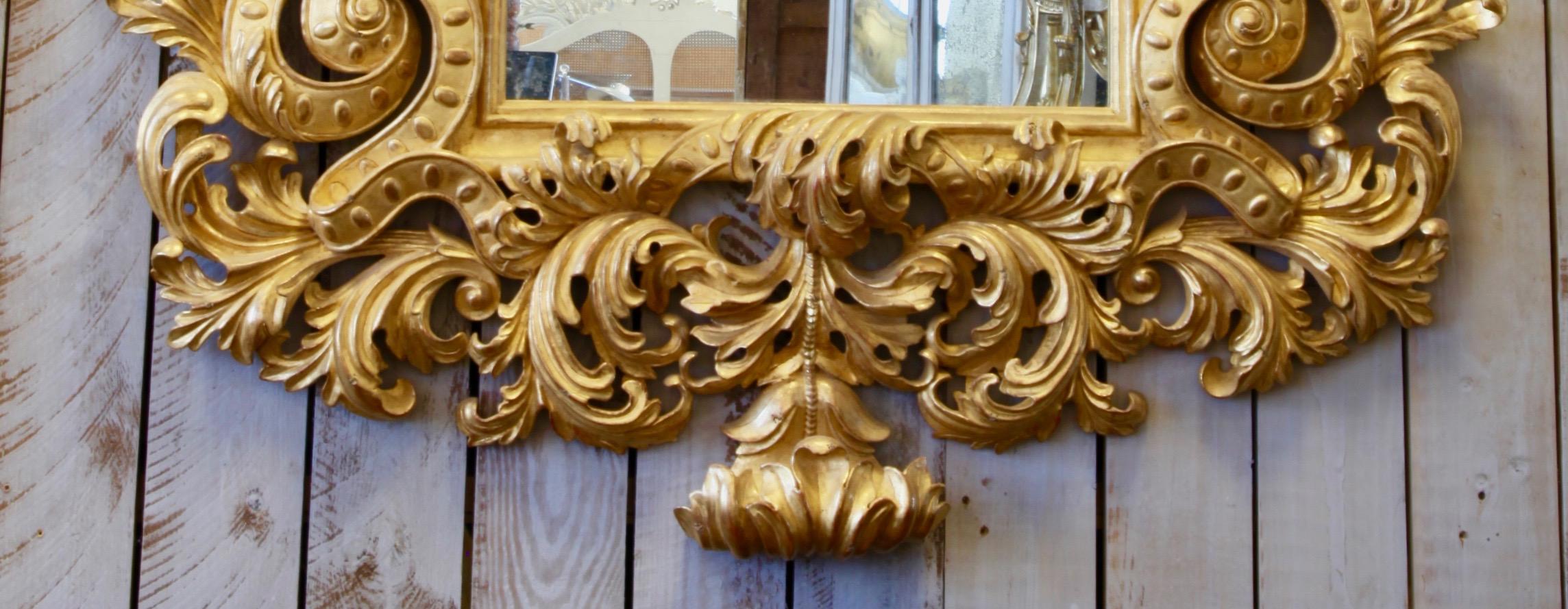 An impressive, large mirror, hand carved in the LXV style featuring spectacular and finely carved voluptuous acanthus leaves. The mirror has been hand gilded in 23.5-karat gold leaf and finished with a lightly aged and distressed patina.

 