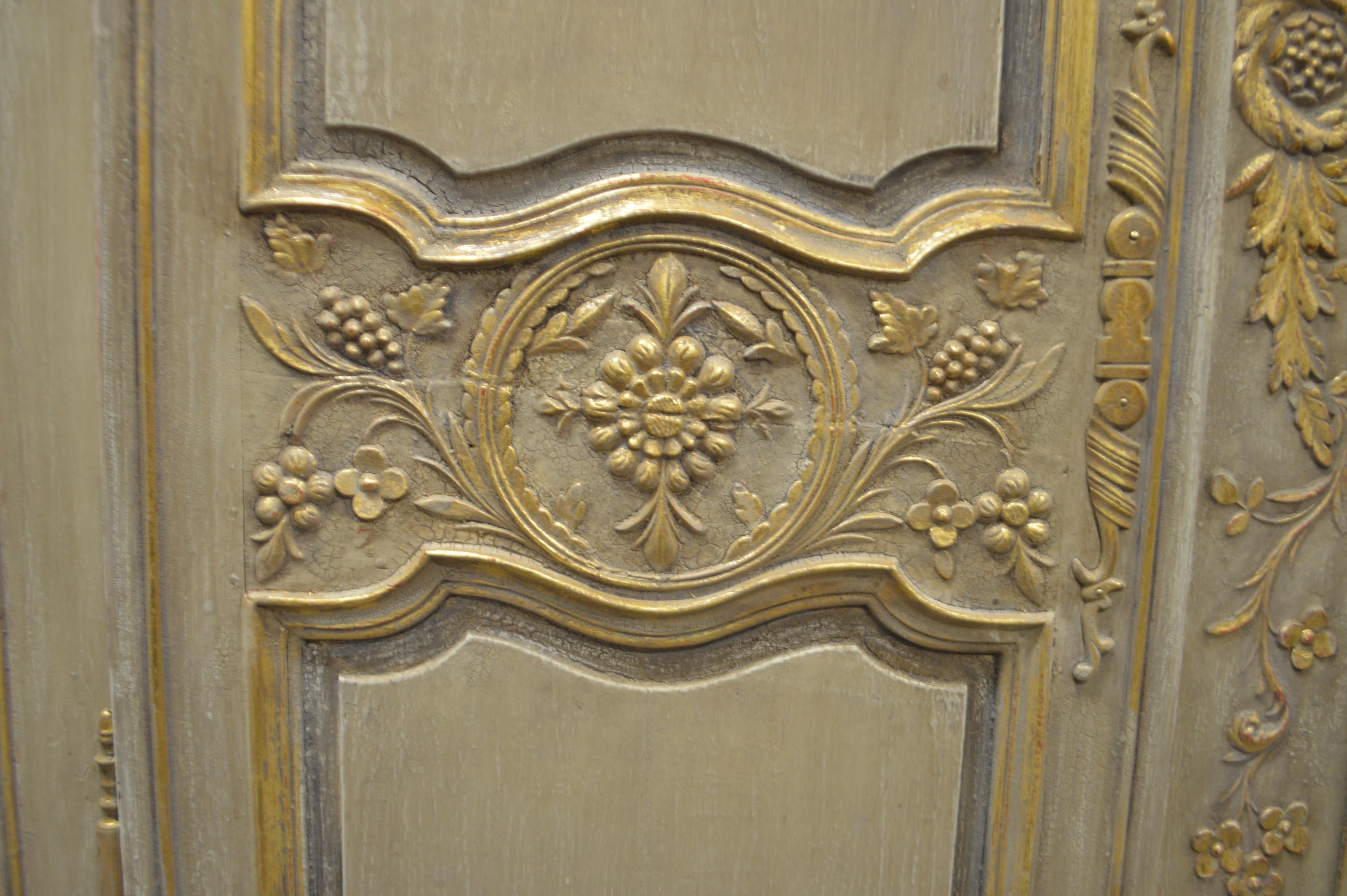 Louis XV style armoire, highly decorative, painted in a neutral tone with gold leaf details. The armoire is of the 19th century painted over solid
oak. There are fives shelves including the base and one drawer that opens from the outside. All the
