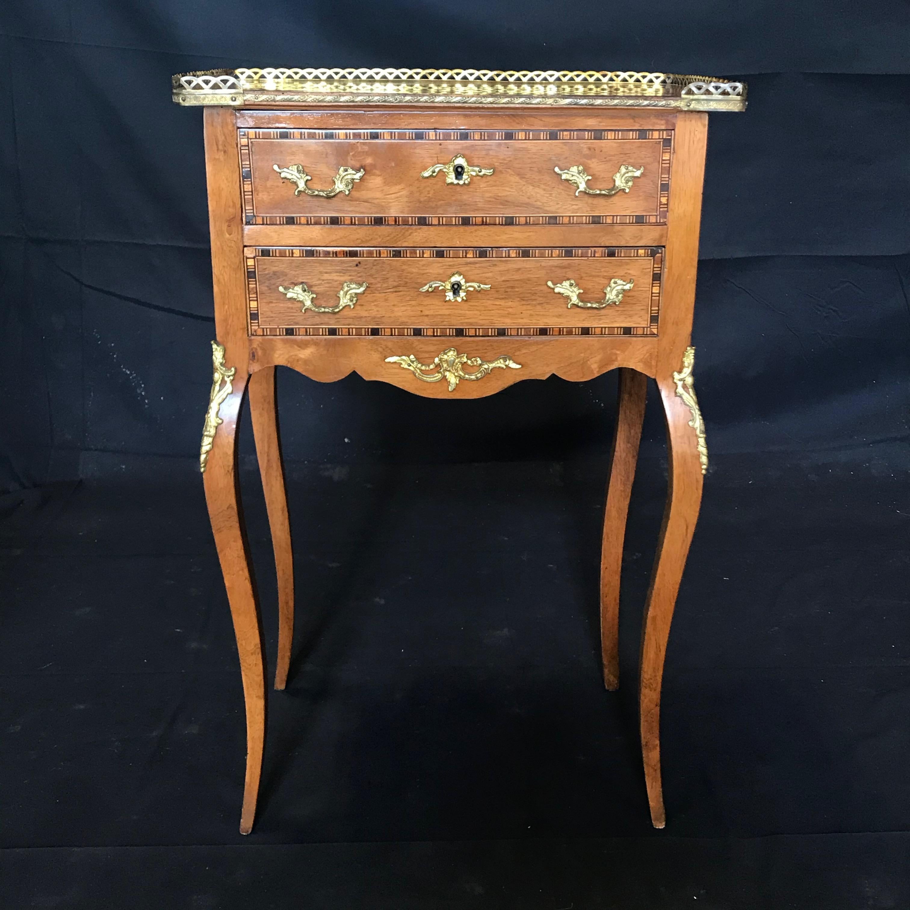 Sumptuous French Louis XV style walnut inlaid nightstand or side table having two dovetailed drawers above a carved apron and exquisite gold fretwork and ormolu decoration. The fruitwood and ebony geometric inlay is exquisite.
#5777

Measures: H