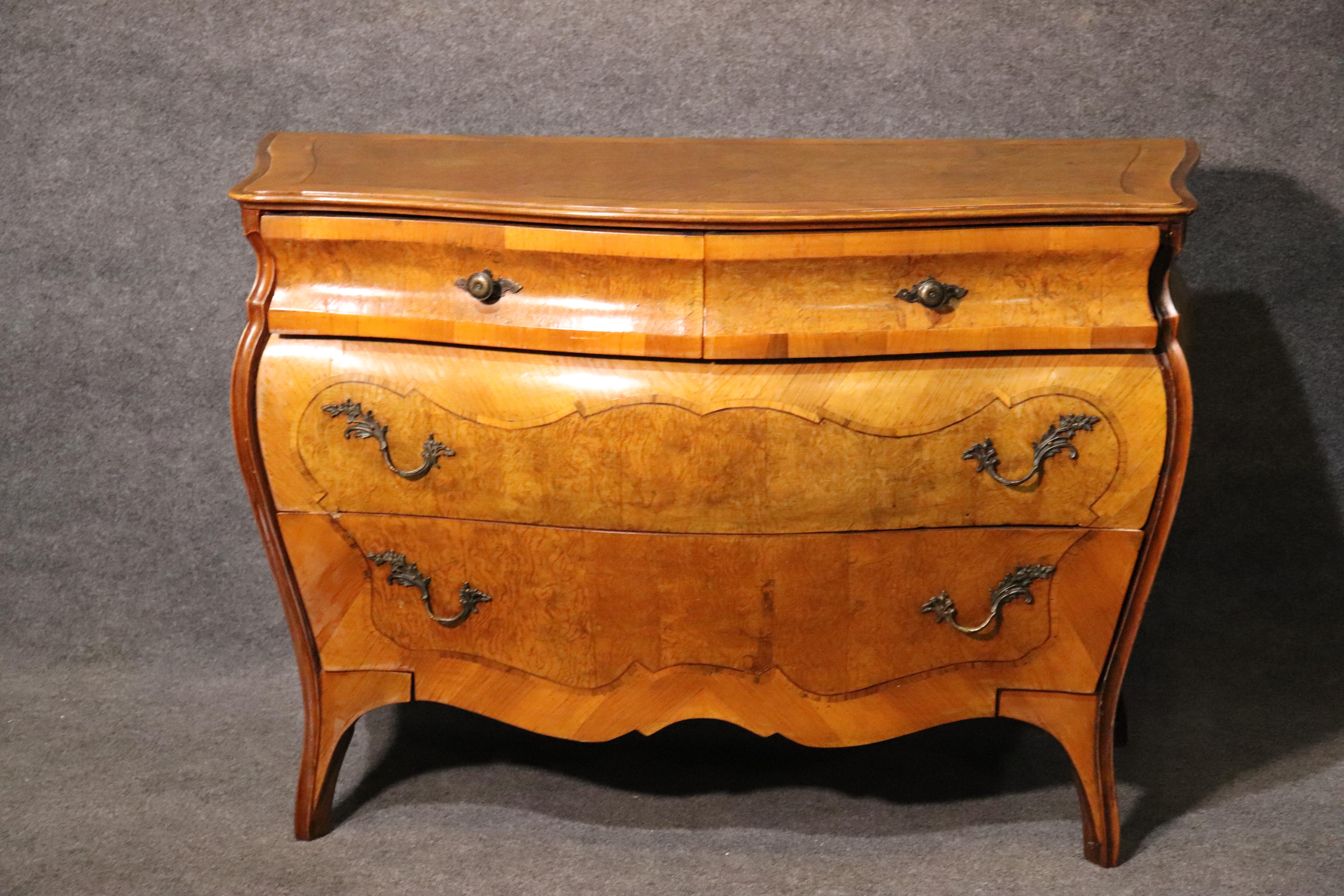 This is a gorgeous burled olivewood commode with simple lines and simple charm. The piece is perfect for a foyer or a bedroom or anywhere that needs the lines, but without the fuss of something too fancy. This piece measures 48 wide x 21 deep x 33