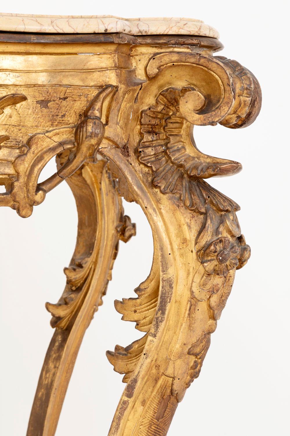 Louis XV style Italian console in carved and gilt wood, standing on four cabriole legs with lion paws shoes. The stretcher is adorned with scrolls finishing in circular element and supporting a flower vase. Curved apron decorated with flowers,