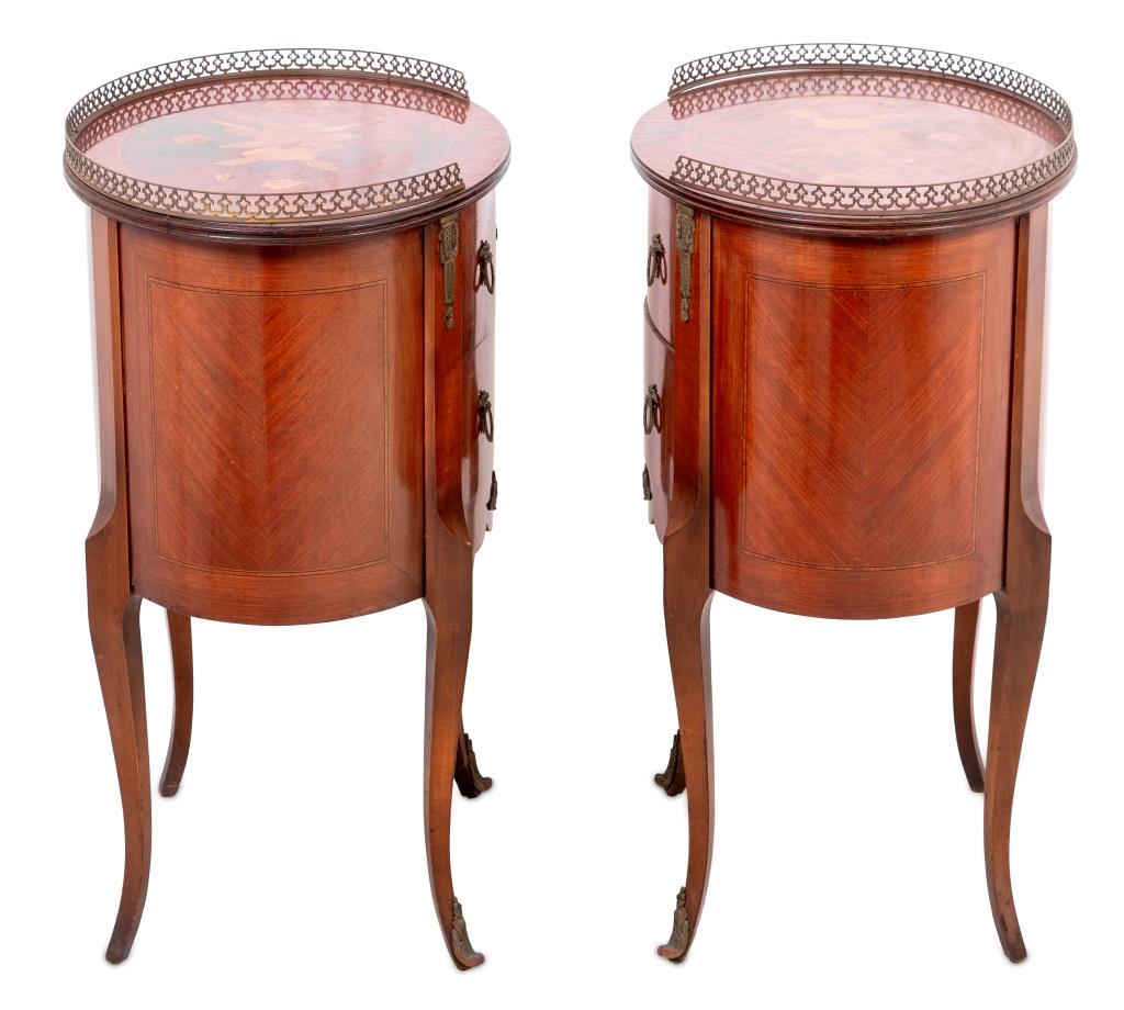 Paire de tables de chevet ovales en bois de roi et marqueterie de style Louis XV montées sur métal doré, XXe siècle, chacune à galerie trois quarts au-dessus d'un plateau floral marqueté, munie de deux tiroirs sur de hauts pieds cabriole, avec
