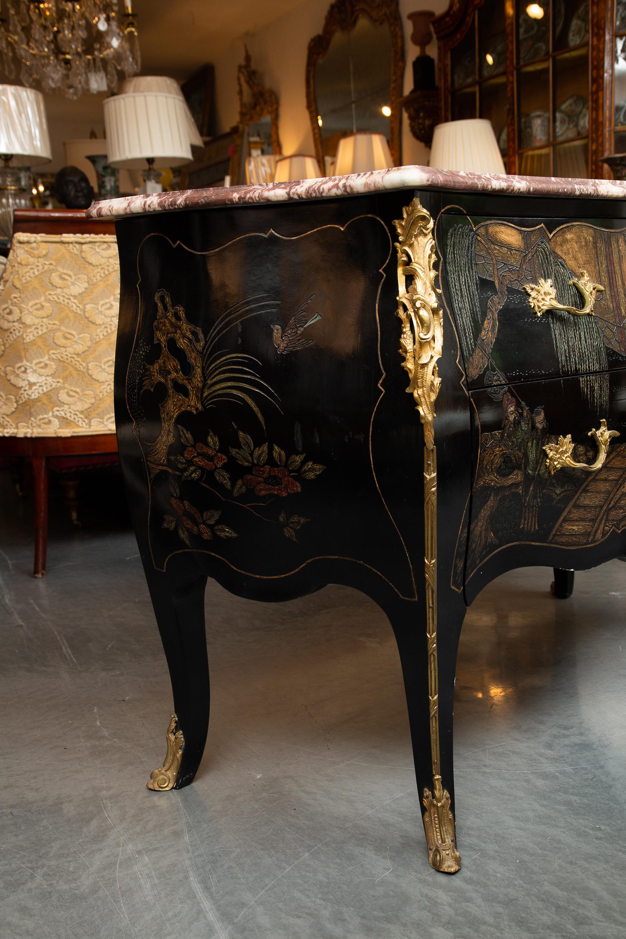 This is a lovely statement-making Louis XV style black lacquered commode, with a variegated marble top, decorated overall with chinoiseries depicting a Chinese village scene.