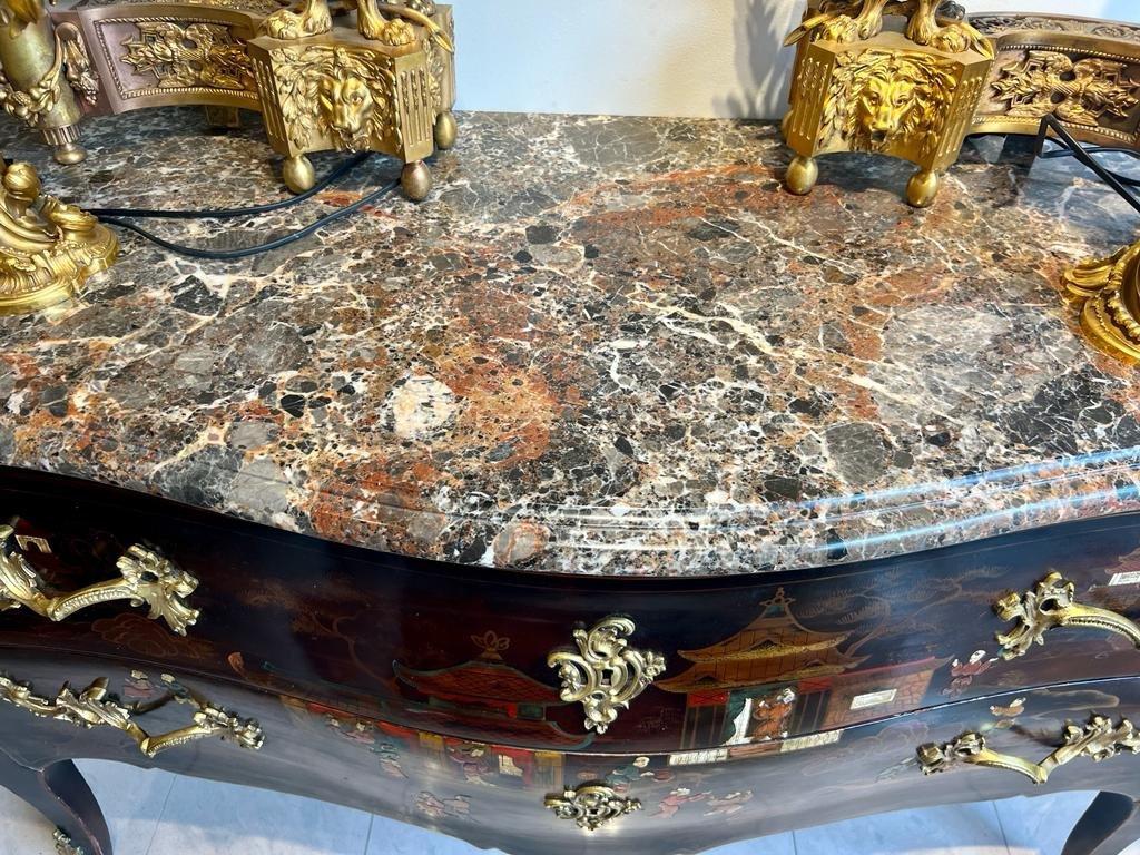 Transition Louis XV-style commode with two drawers sans cross pieces in striking black Chinese lacquer, standing on four cabriole legs. Embellished with vibrant scenes from Imperial China palace life, featuring numerous characters in traditional