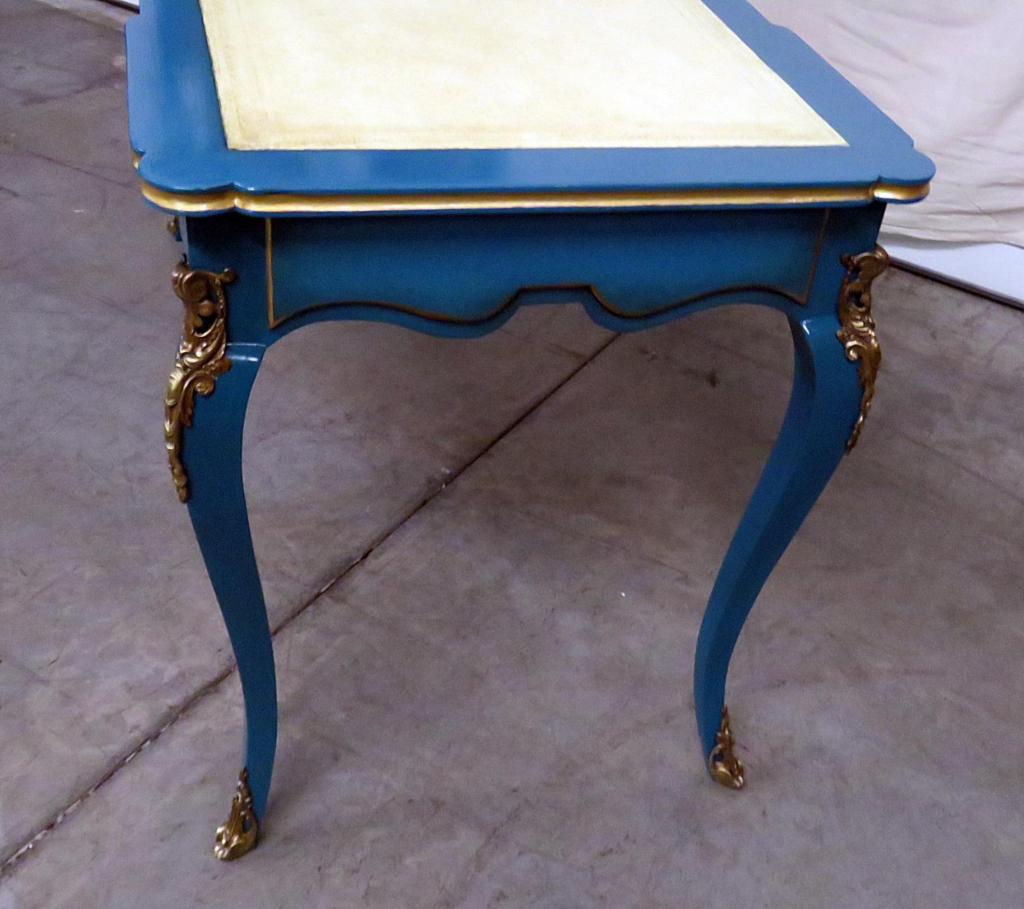 Attributed to Maison Jansen, This beautiful French blue painted desk is like a jewel. The Louis XV style lacquered leather top Cartonnier desk with gilt accents has utility and chic design blended together. The top contains 2 doors with 2 shelves