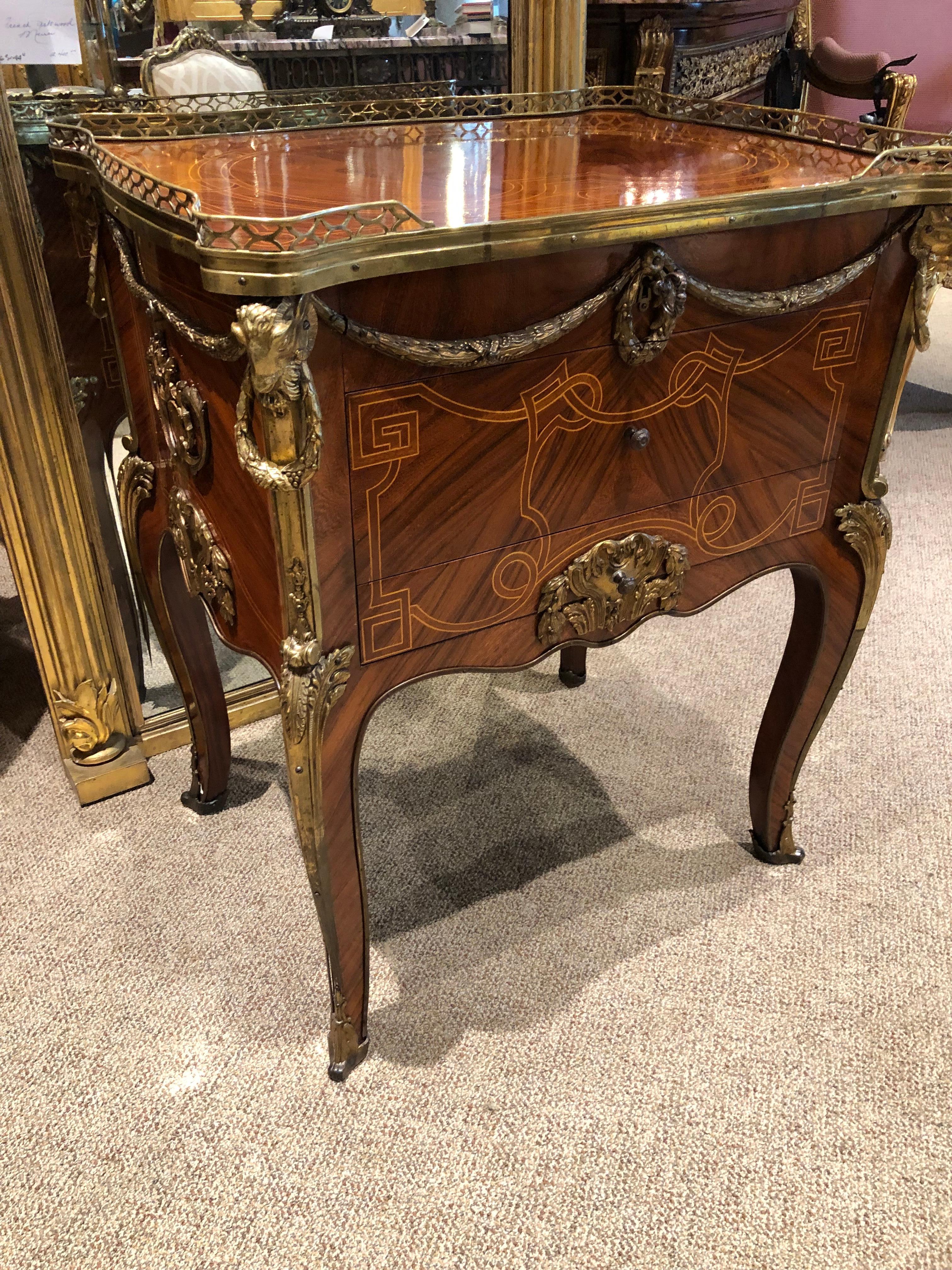 Rectangular top with projecting corners and a
Three-quarter pierced brass gallery, above a
Conforming case fitted with three drawers, all
With applied ormolu mounts, raised on cabriole
Legs ending in sabots, the whole with decorative
Inlaid