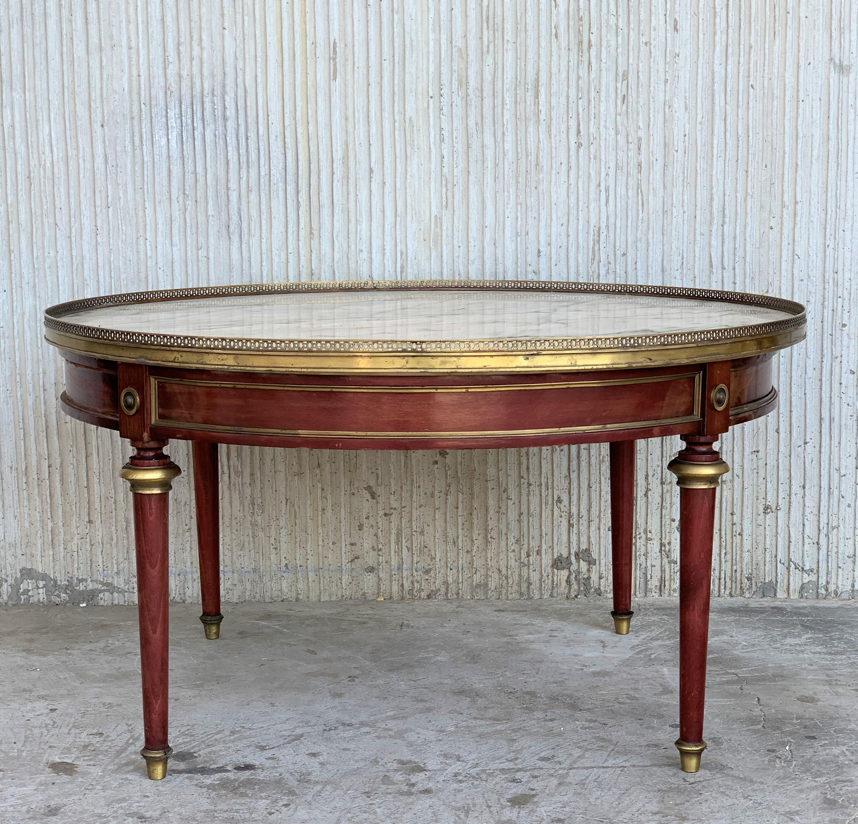 This elegant Louis XV style marble top coffee table is made out of mahogany with four tapered legs. The table has exquisite detailed bronze mounts and a bronze band around the marble top.


 
