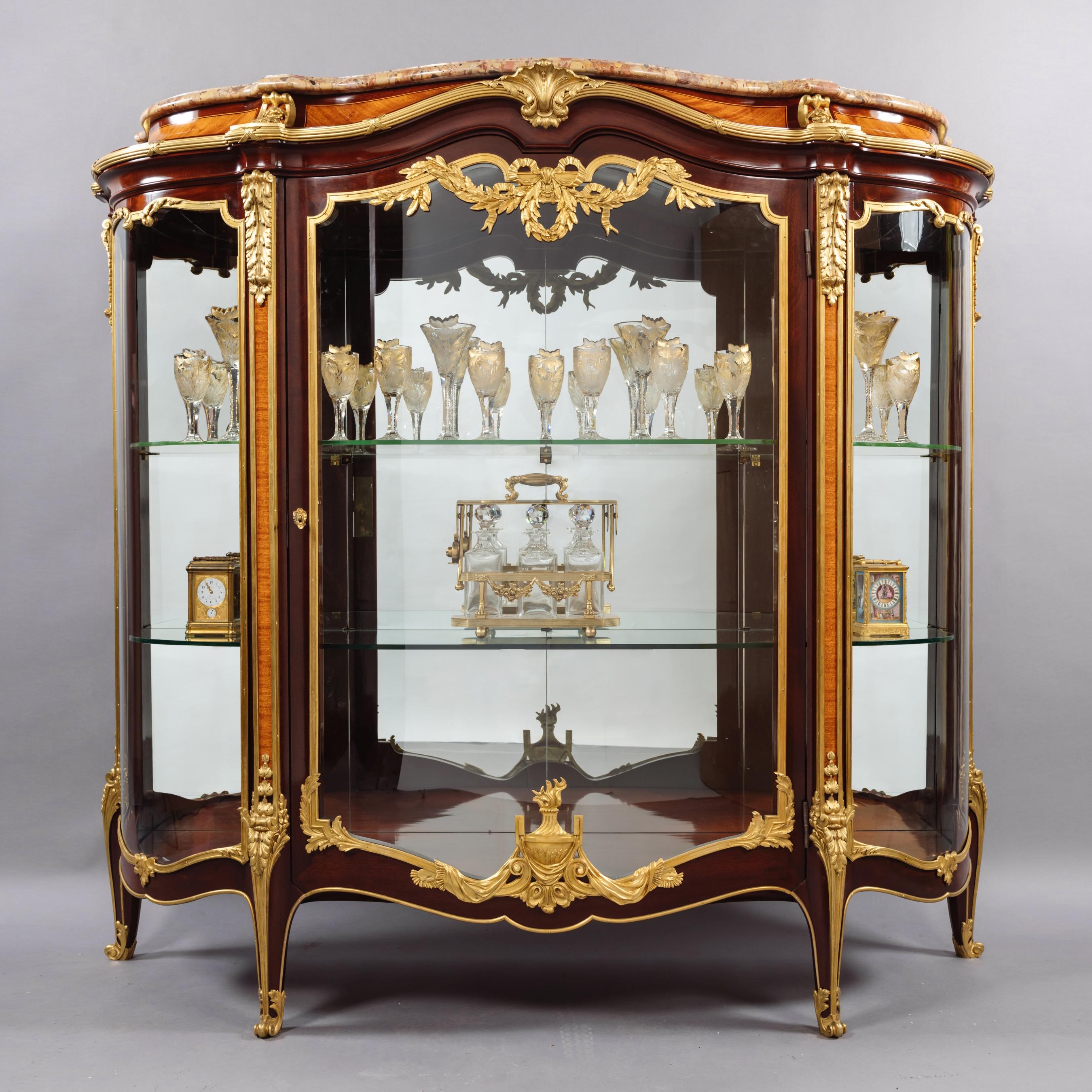 A fine Louis XV style gilt-bronze mounted mahogany bombé vitrine by François Linke.

Signed to the corner clasp 'F. Linke'.

This elegant bombé shaped vitrine has a shaped brèche d'Alep marble top above a conforming case fitted with a shaped