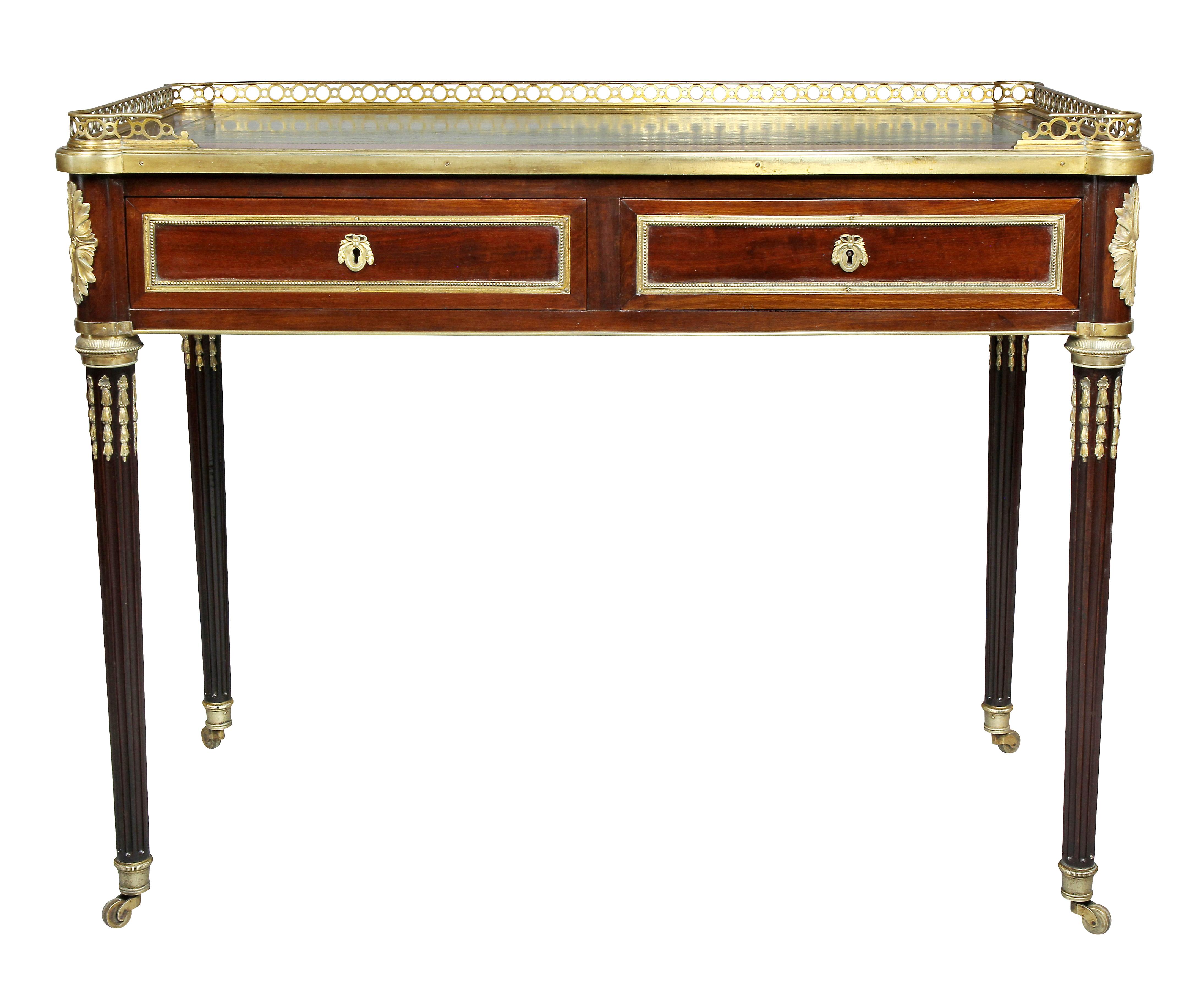 With rectangular top with 3/4 bronze gallery and green leather writing surface over two drawers with ormolu trim, pull out candle slides, raised on circular tapered fluted bronze mounted legs ending on casters. Palm Beach Estate.