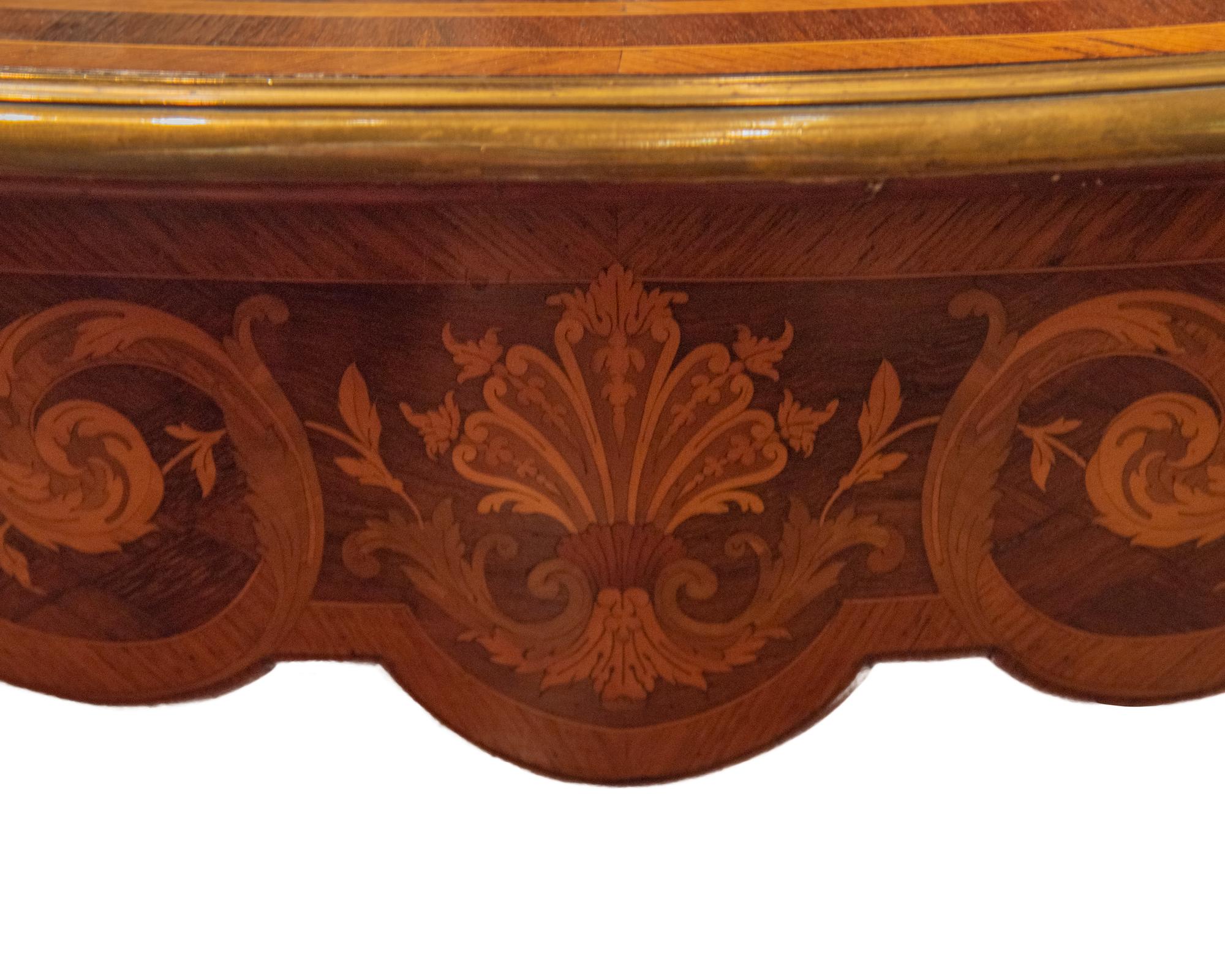 A large French 19th century Louis XV style kingwood, tulipwood and ormolu desk or writing table. The table is raised by slender cabriole legs with foliate ormolu sabots. An ormolu chute leads up each leg to a foliate corner mount. The shaped frieze