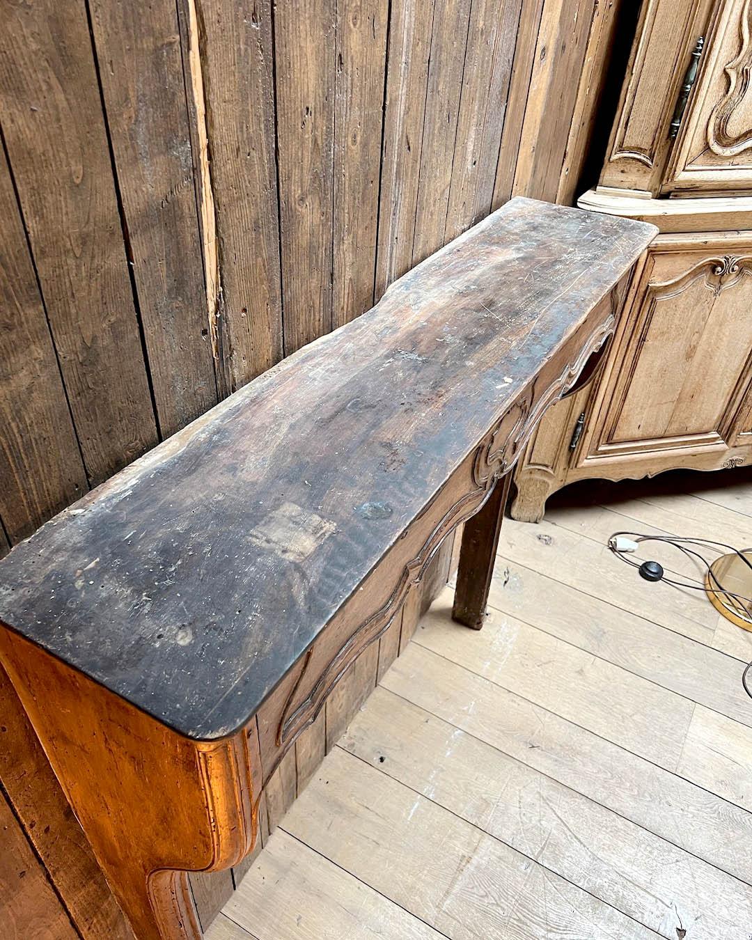 Questa elegante cappa per camino in quercia è realizzata in stile Luigi XV e si distingue per le sue curve aggraziate, il grembiule smerlato e i raffinati motivi intagliati a mano. La calda patina di quercia ne esalta il fascino autentico, mentre le