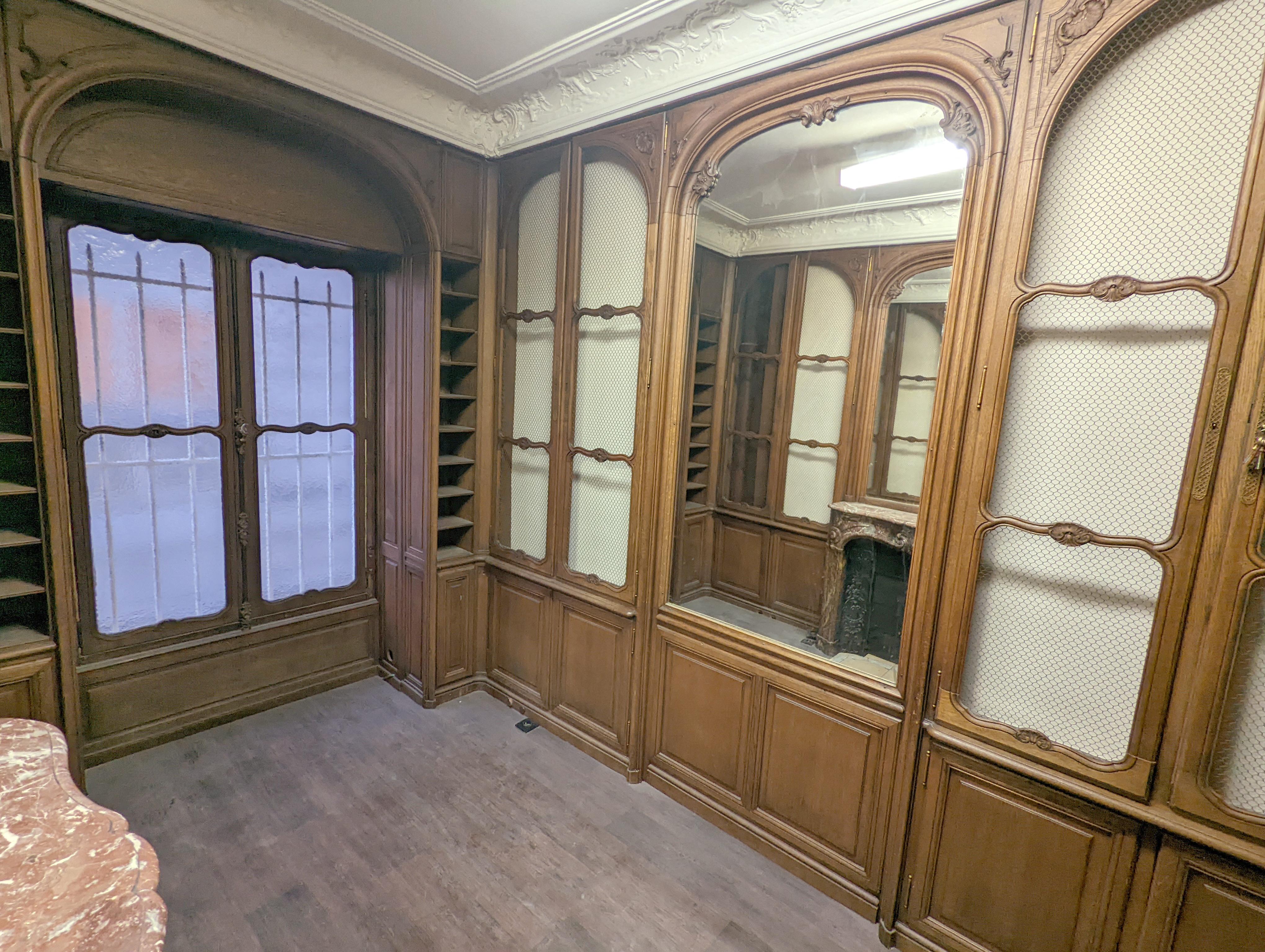 French Louis XV style oak paneling and bookcase including a fireplace mantel. For Sale