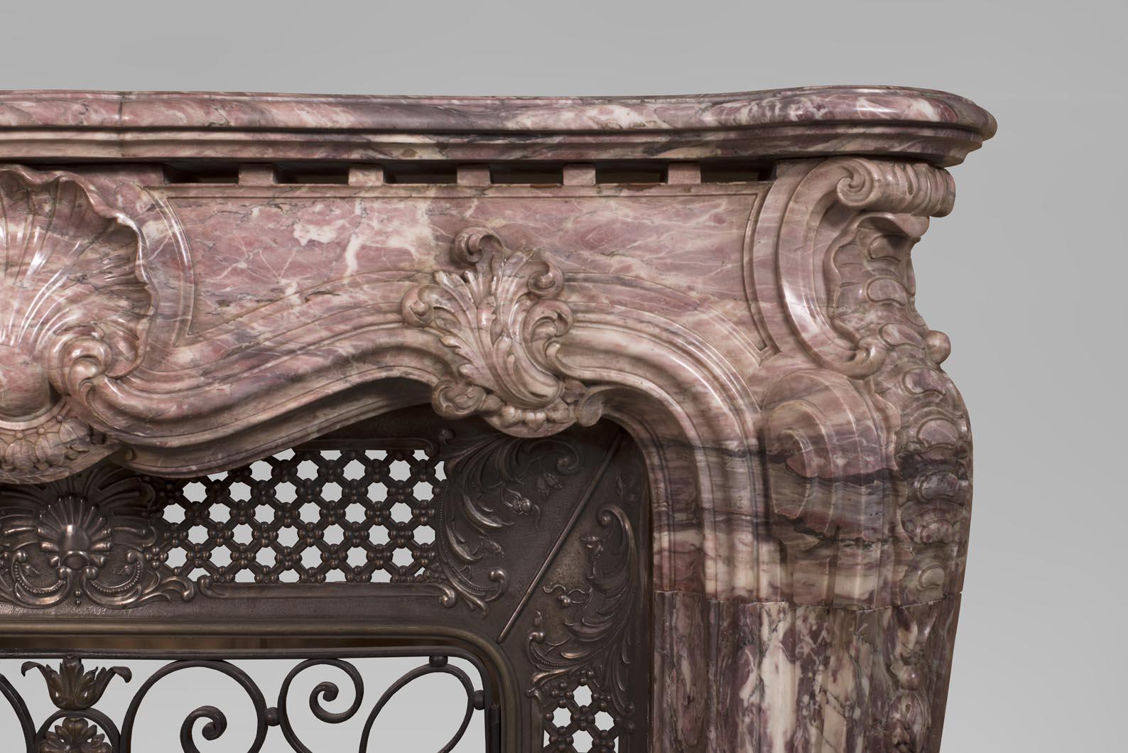 Marble Louis XV style opulent fireplace sculpted out of Fleur de Pêcher marble For Sale