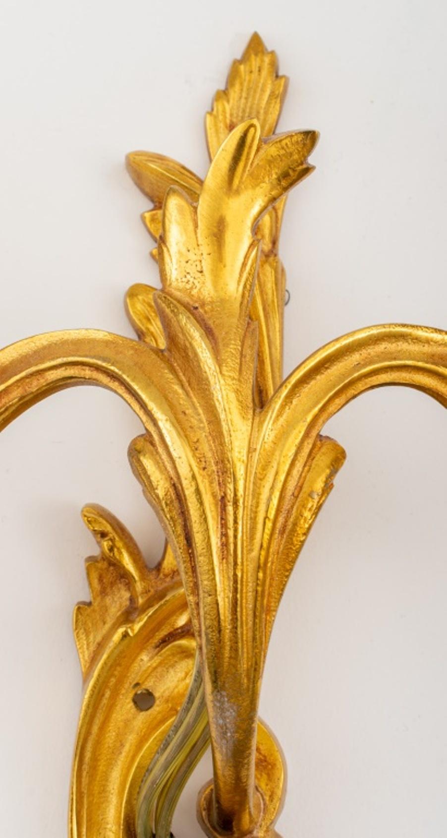 Belle Epoque Louis XV style ormolu two-light sconces, likely circa 1900, each of scrolling foliate rocaille-form with two asymmetrical arms issuant from a scrolling back plate in the manner of Caffieri. 

Dealer: S138XX