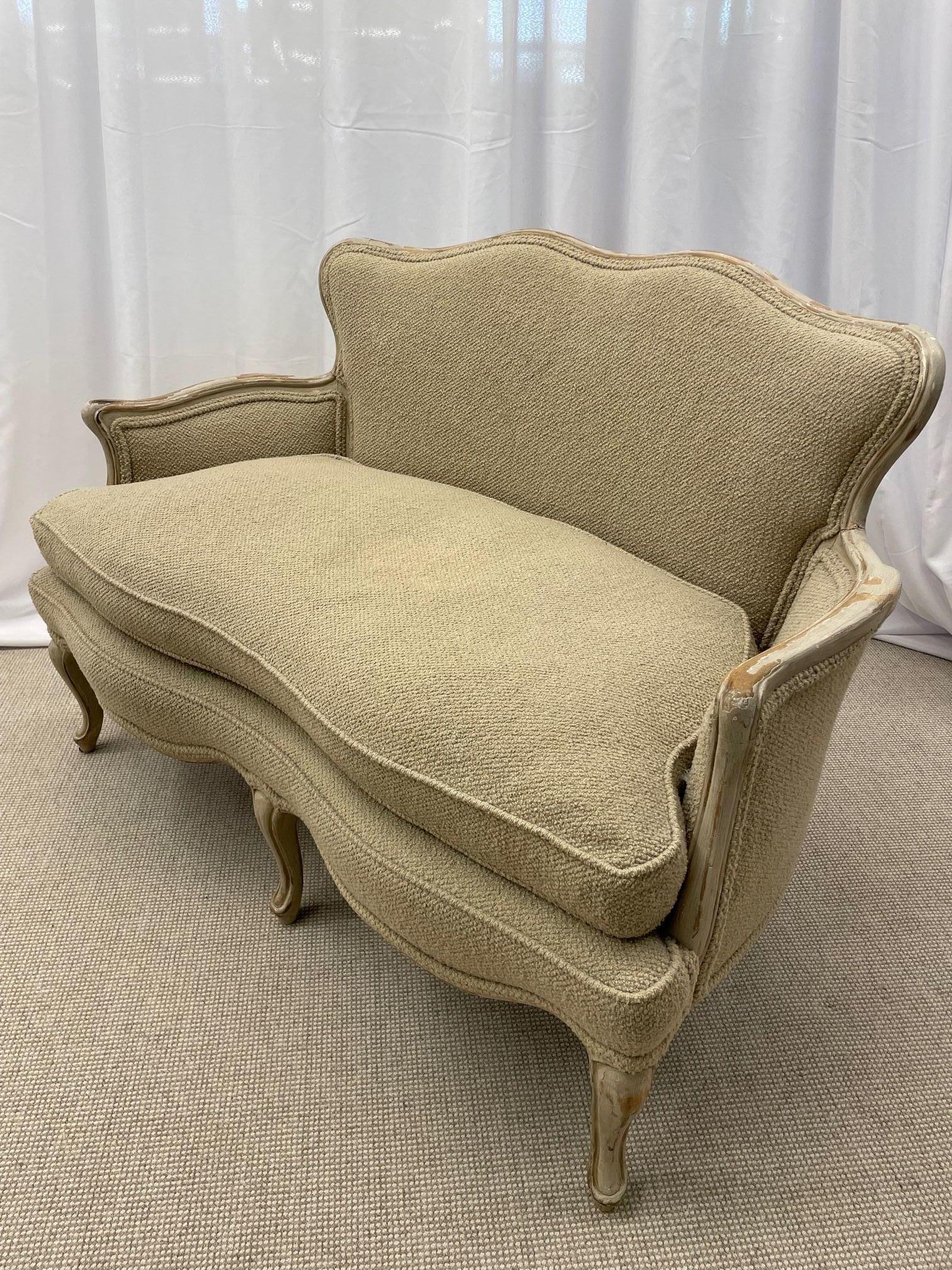 Swedish style parcel gilt and paint decorated sofa, settee or loveseat in the Louis XV Fashion. This finely detailed settee has been recently recovered in a Beige Bouclé Fabric by John Shays. This Elegant yet rustic two person settee having a