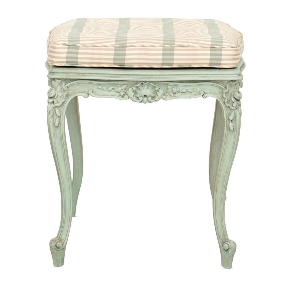 Experience the elegance of French design with our extraordinary antique footstool, crafted in the Louis XV style. This exquisite piece has been meticulously painted and upholstered, reflecting a dedication to preserving its historic charm while